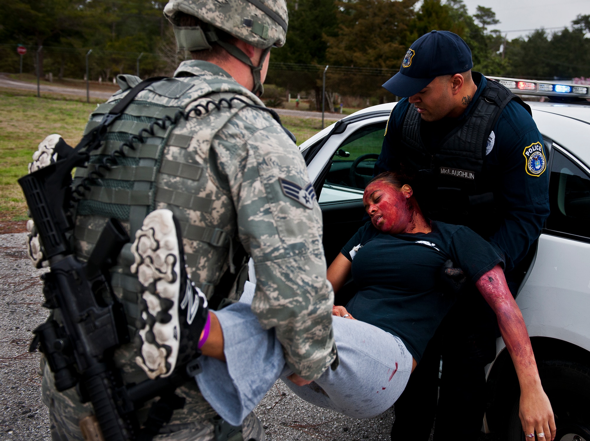 A victim is loaded into a squad car by 96th Security Forces Squadron personnel during the active shooter exercise at Eglin Air Force Base, Feb. 6.  The Security Forces Airmen entered the building to apprehend the suspect, assess the wounded and report back information to the emergency responders.  (U.S. Air Force photo/Samuel King Jr.)