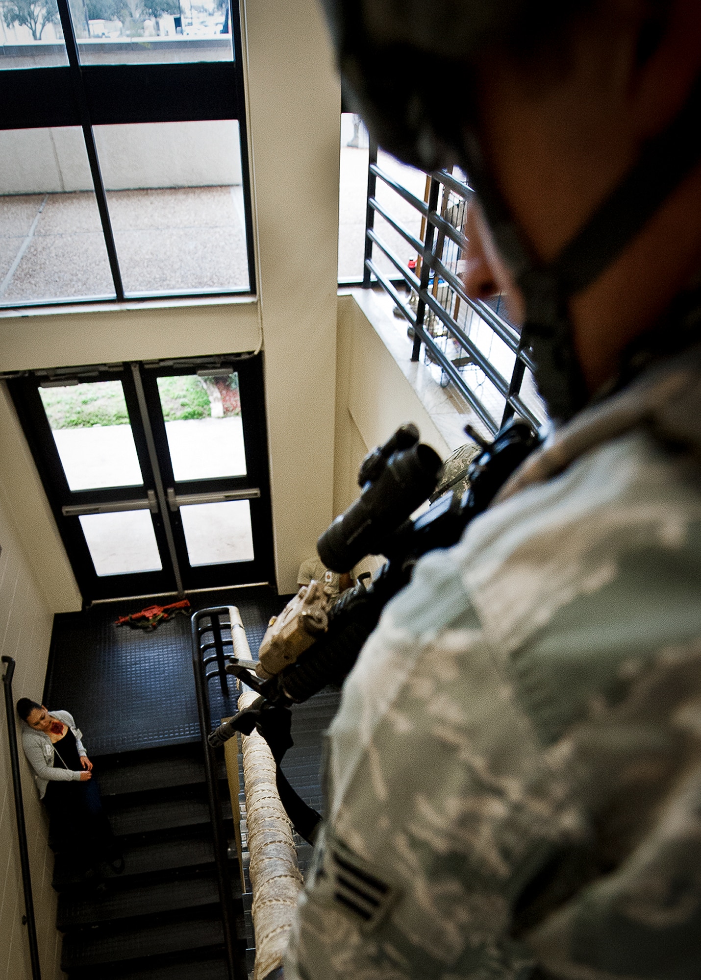 Senior Airman Michael Fisk, of the 96th Security Forces Squadron, checks the stairway before descending to the victims during an active shooter exercise at Eglin Air Force Base, Feb. 6.  The Airmen entered the building to apprehend the suspect, assess the wounded and report back information to the emergency responders.  (U.S. Air Force photo/Samuel King Jr.)