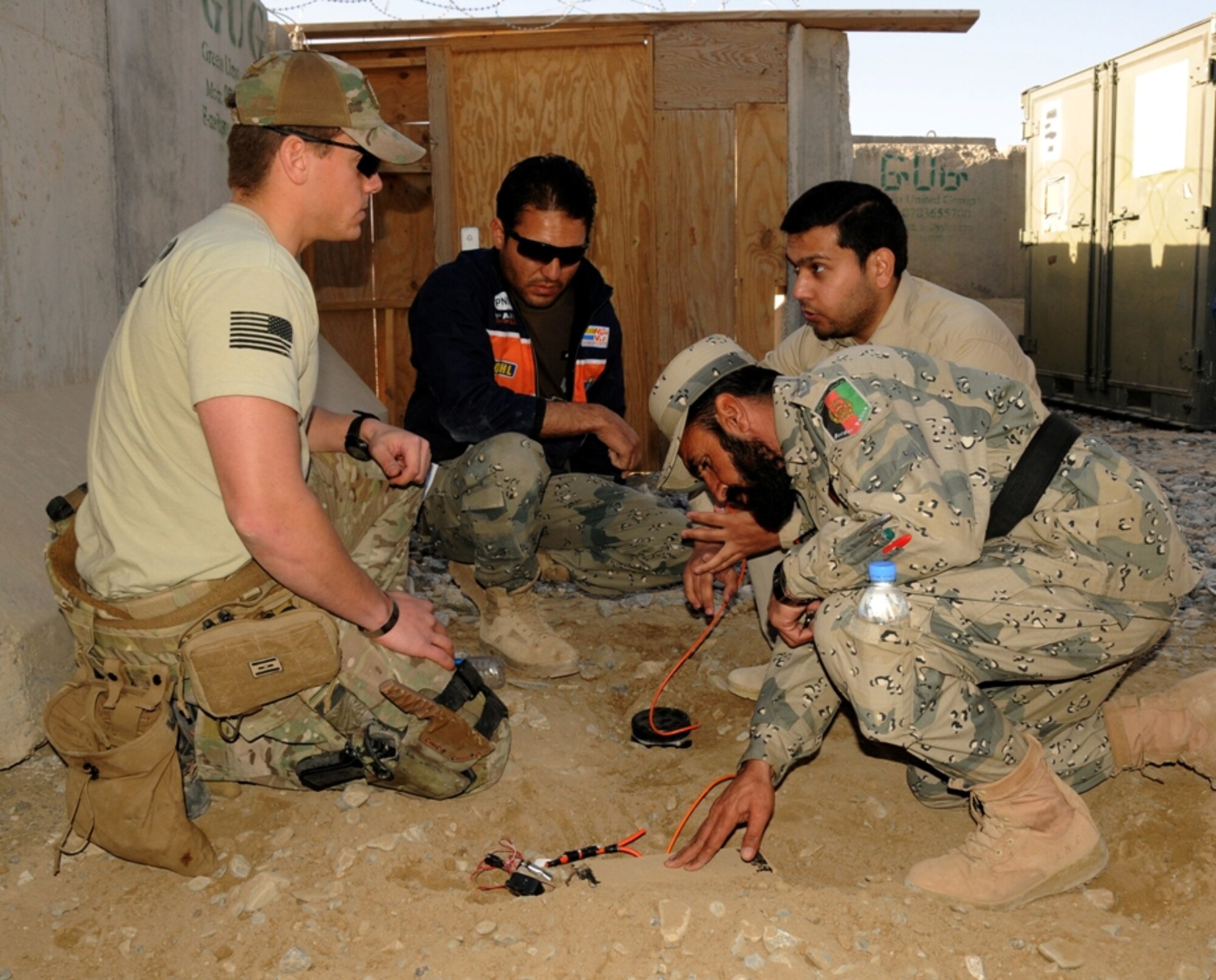 Staff Sgt. Allen P. Middaugh, an explosive ordinance disposal technician with Team 6, 466B Flight, Task Force Paladin discusses the components of an improvised explosive device with Afghan Border Police EOD personnel during a joint training session Feb. 6, 2013, here. The training allowed International Security Assistance Force personnel to validate the ABP EOD certifications. (U.S. Army Photo by Staff Sgt. Shane Hamann, 102nd Mobile Public Affairs Detachment.)