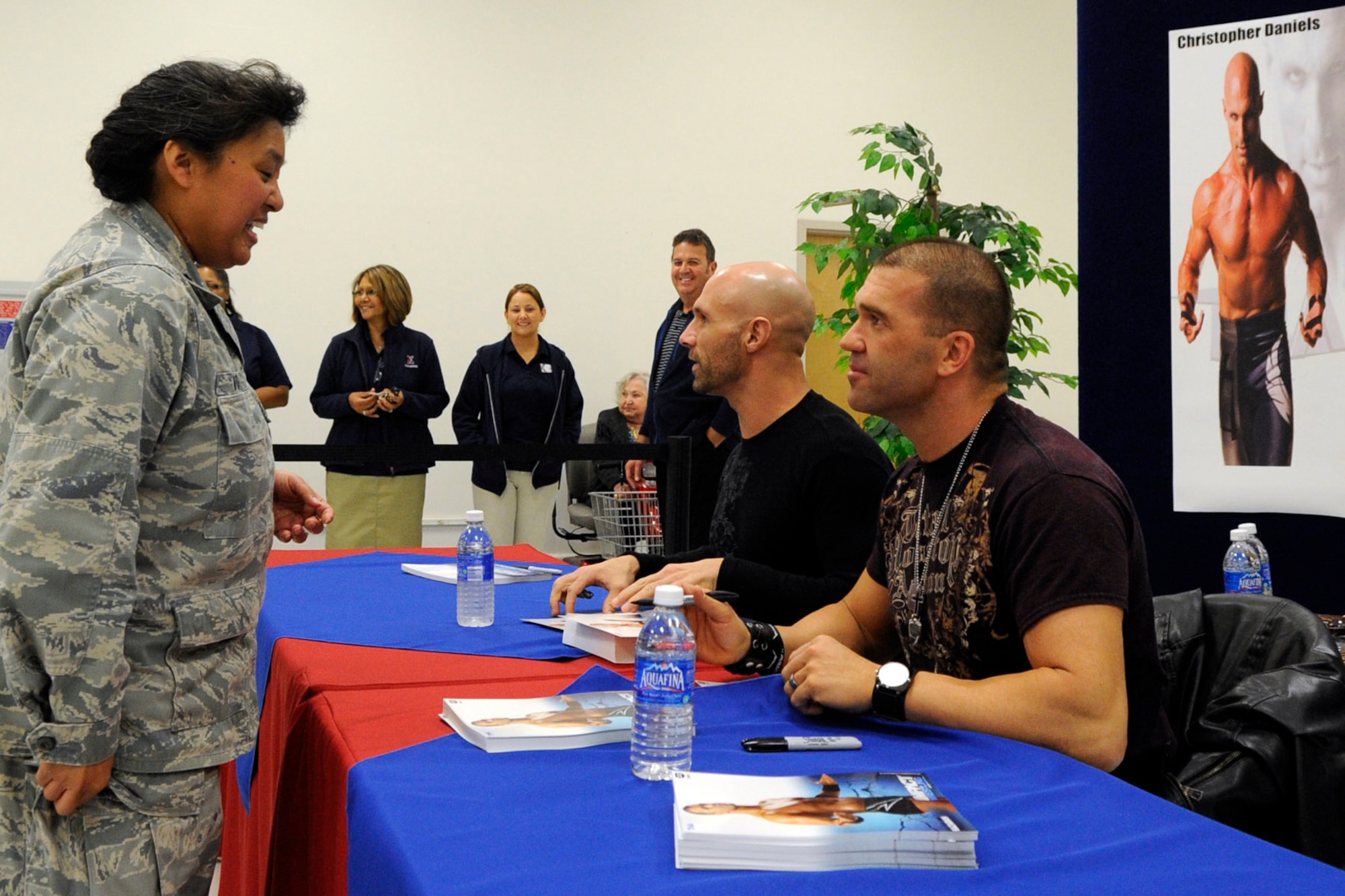 Lt. Col. Sandra Volden, a physician assigned to the 307th Medical Squadron, gets autographs for her daughter from Total Nonstop Action wrestlers, Christopher Daniels and Frankie Kazarian, during a meet and greet session at the Barksdale Exchange on Barksdale Air Force Base, La., Feb. 8, 2013. The two wrestlers competed during the Road to Lock Down event at the Centurylink Center in Bossier City, La., Feb. 8. (U.S. Air Force photo by Master Sgt. Jeff Walston)