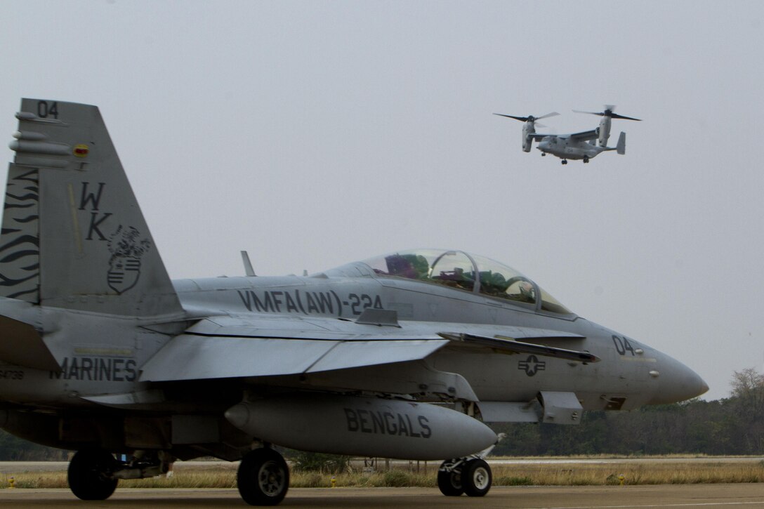 An MV-22B Osprey prepares to land as an FA-18D Hornet taxis forward at Wing One Royal Thai Air Force Base, Nakhon Ratchasima, Kingdom of Thailand, Feb. 8 in preparation for exercise Cobra Gold 2013. CG13 is designed to advance regional security and build capacity to effectively respond to regional crises by exercising a robust multinational force from nations sharing common goals and security commitments in the Asia-Pacific region. The Osprey is assigned to Marine Medium Tiltrotor Squadron 265, Marine Aircraft Group 36, 1st Marine Aircraft Wing, III Marine Expeditionary Force. The Hornet is assigned to Marine All Weather Fighter Attack Squadron 224, MAG-12, 1st MAW, III MEF. (U.S. Marine Corps photo by Lance Cpl. Todd F. Michalek/Released)