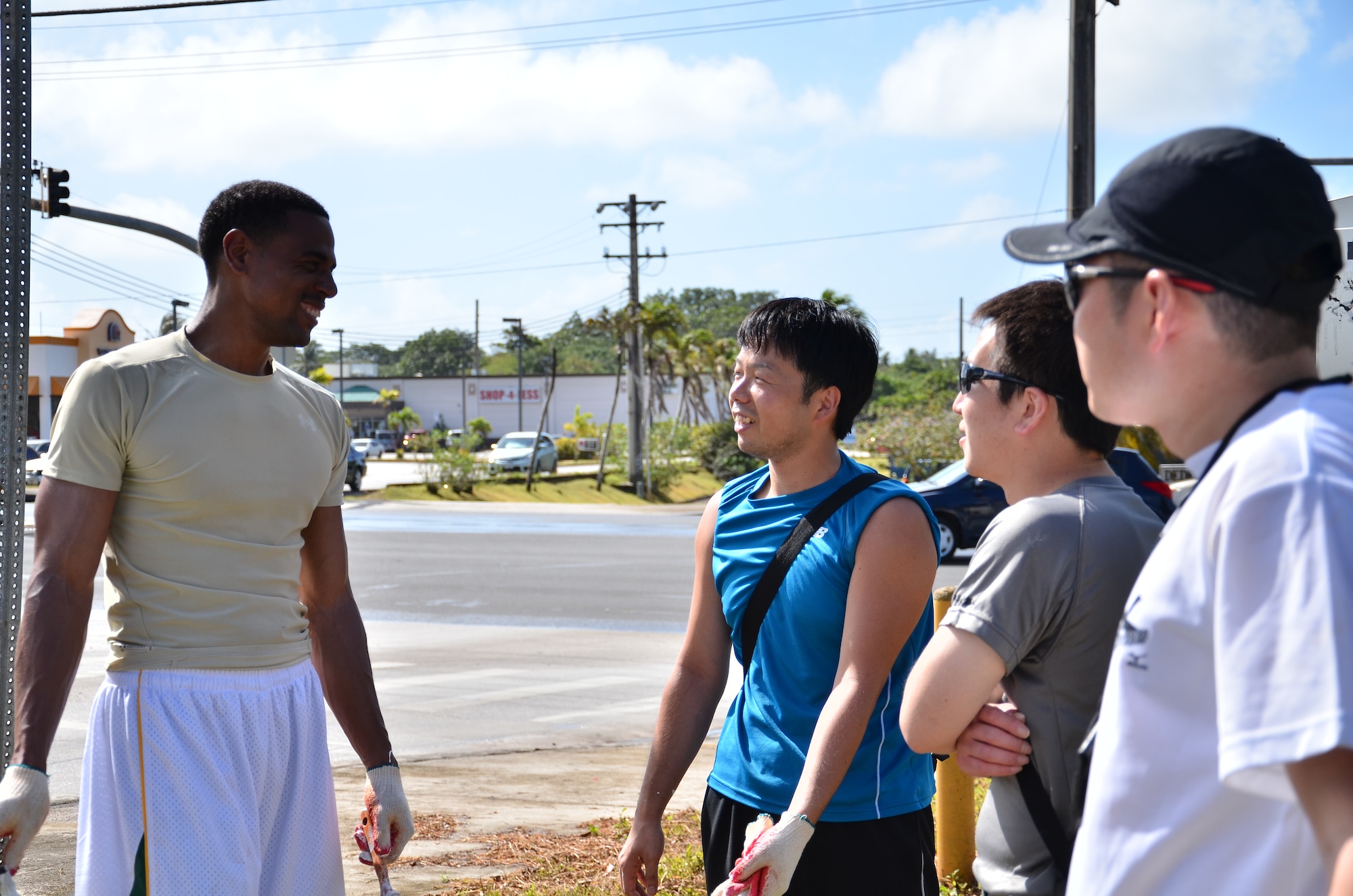 Personnel from the U.S. Air Force and Japan Air Self-Defense Force take a break and talk about where they are from while painting street side columns in Dededo, Guam on Feb. 9, 2013. More than 170 personnel from the U.S. Air Force, Japan Air Self-Defense Force and Royal Australian Air Force, all on Guam as participants in Cope North 13, volunteered at four local sites in Dededo, thanking the community for their support during the two-week exercise.  (U.S. Air Force photo by Staff Sgt. Alexandre Montes/RELEASED) 
