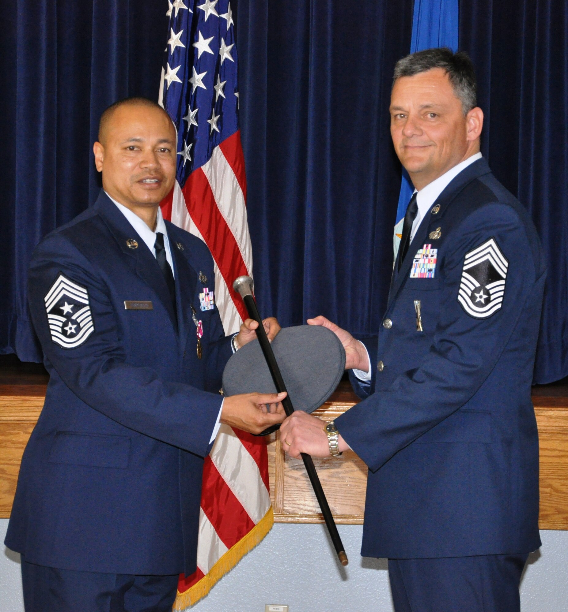 CMSgt Jason Henderson hands the hat and cane to CMSgt Denny Brown, signifiying Brown's position as the new wing command chief, during a retirement/ installation ceremony held Feb 10, during the UTA.  Chief Henderson retires from the US Air Force after 24 years of service, four of which were as the command cheif of the 940th Wing.  (U.S. Air Force photo/SrA Adam Hamar)