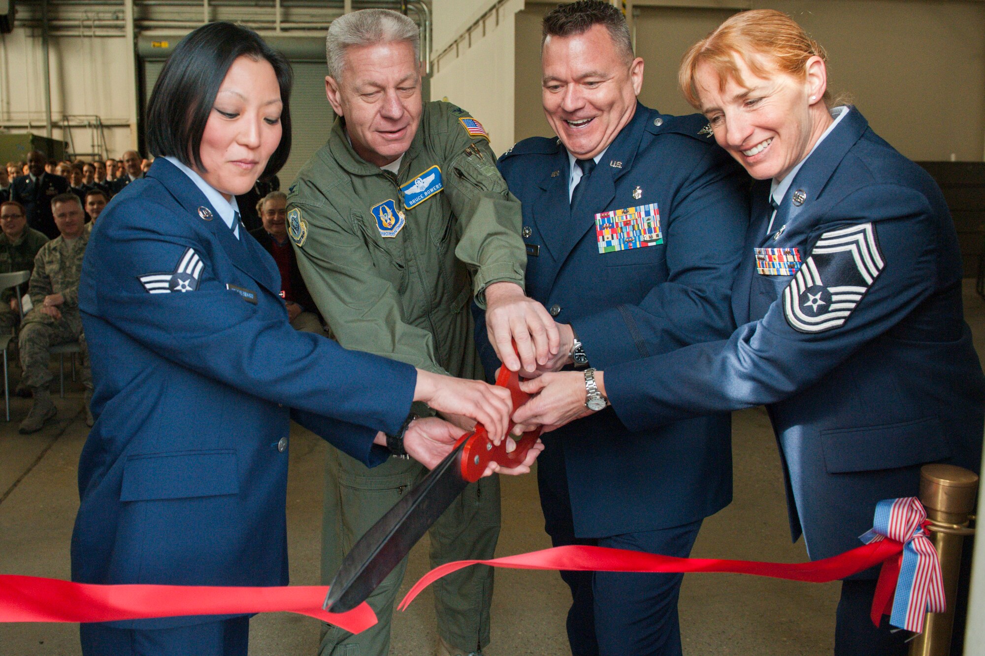Members of the 446th Aeromedical Staging squadron (left and right) cut the ribbon to their new facility at Hangar 12 on Feb. 9 with the 446th Airlift Wing Commander Col. Bruce Bowers (middle left) and commander of 446th ASTS Col. Rob Richardson (middle right). The new facility's location on the flight line allows them to store all of their equipment in one place and practice more hands-on training. (courtesy photo from Douglas Olsen Photography)