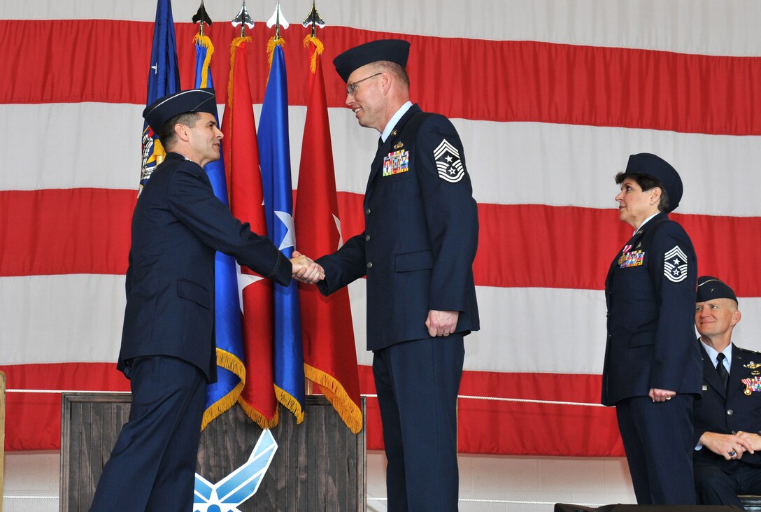 Col. Brian Simpler (left), Commander, 125th Fighter Wing, passes the unit coin to newly appointed 125th Fighter Wing Command Chief, Chief Master Sgt. Mike Seger at a Change of Authority Ceremony here February 10, 2013. Chief Master Sgt. Seger follows former Command Chief Sharon Ervin (right), who spent six years as the 125th Fighter Wing Command Chief Master Sgt. (USAF Photo by MSgt. Shelley Gill)