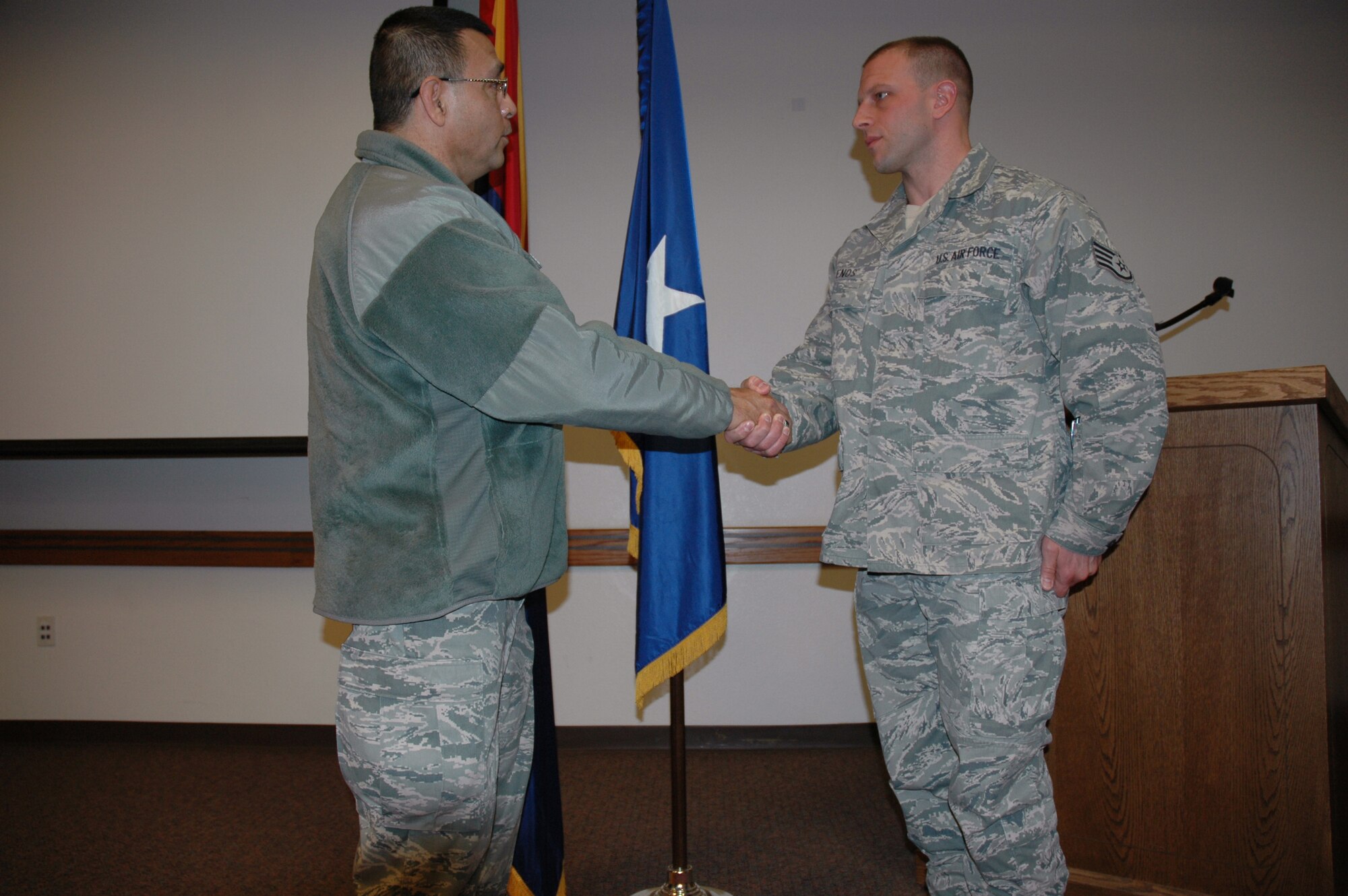 Brig. Gen. Jose Salinas, Director, Joint Staff Arizona National Guard presents Staff Sgt. Christopher Enos, food specialist, 161st Force Support Squadron, Phoenix, with his personal coin for his hard work during the 161 FSS support of the 57th Presidential Inauguration in Washington D.C. during the squadrons commanders call Feb. 10, 2013. (U.S. Air Force photo by Staff Sgt. Michael Matkin/Released)