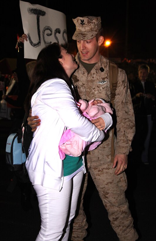 Petty Officer 2nd Class Brian Stearns, a  dental technician with 1st Dental Battalion, 1st Marine Logistics Group, kisses his wife, Andrea, and embraces his three-week-old daughter, Jocelynn Marie, during a homecoming aboard Camp Pendleton, Calif., Feb. 3. Stearns, a native of Marion, Ill., was deployed to Helmand province, Afghanistan for five months. 