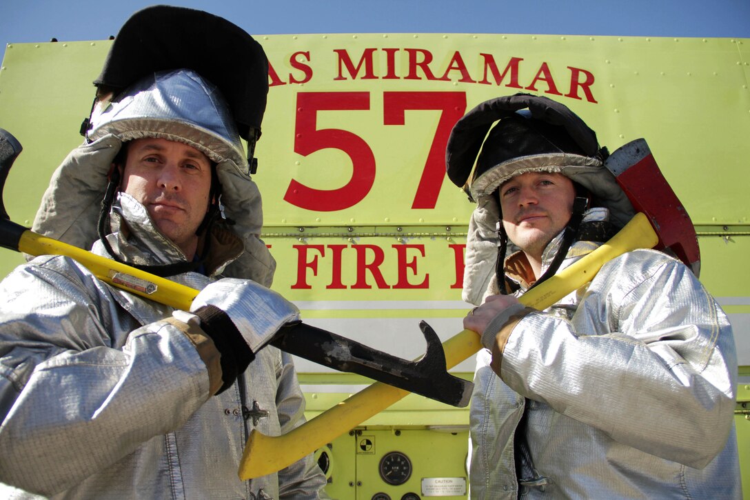 Century High School teachers Aaron Berg and Michael Eckerman don firefighting equipment during a flight line tour Jan. 30. Both attended an educators workshop in California, courtesy of Recruiting Station Twin Cities. For additional imagery from the event, visit www.facebook.com/rstwincities.