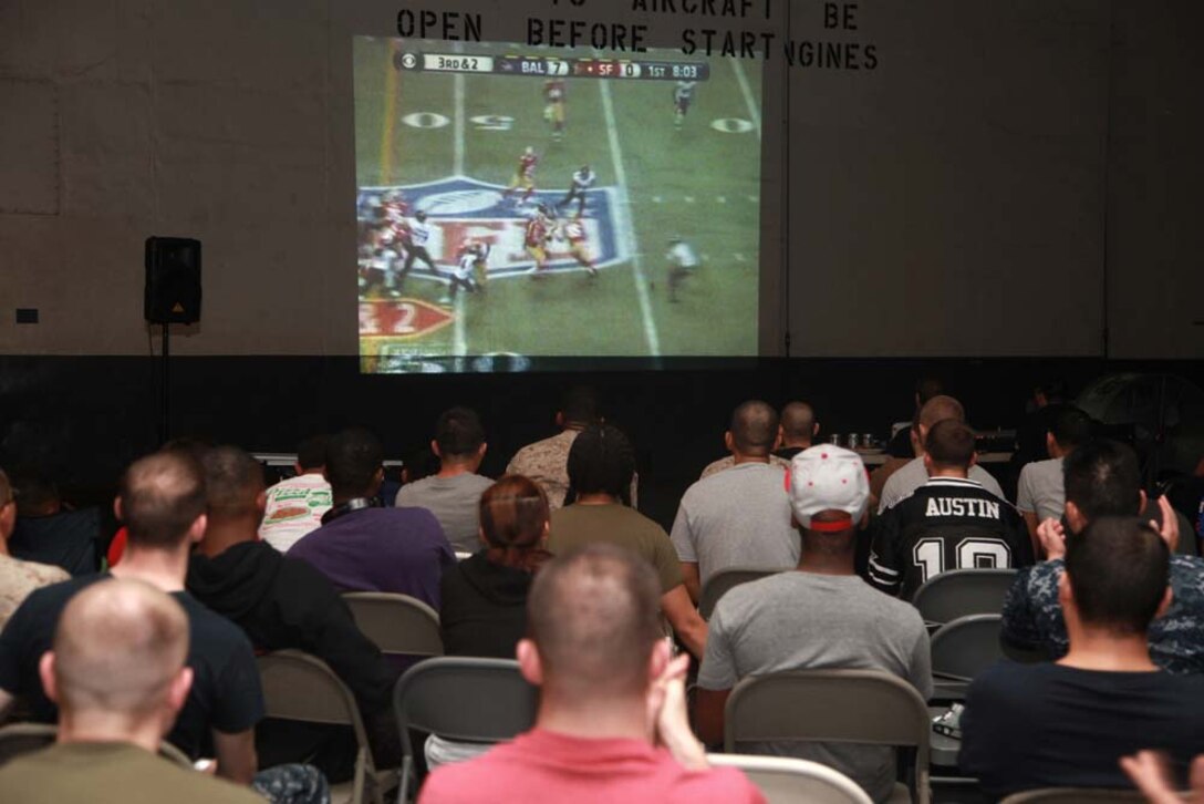 Marines and sailors with the 15th Marine Expeditionary Unit and Peleliu Amphibious Ready Group watch Super Bowl XLVII during the Super Bowl party held in the hangar bay of the USS Peleliu, Feb. 4. The ship hosted a Super Bowl party for its Marines and sailors as a way to help them decompress and enjoy some of the comforts of home while being forward deployed. The 15th MEU is deployed as part of the Peleliu ARG as a U.S. Central Command theater reserve force, providing support for maritime security operations and theater security cooperation efforts in the U.S. 5th Fleet area of responsibility.