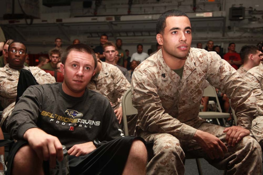 Sergeants Tim J. Kunkoski (left), motor transport non-commissioned officer-in-charge, and Yoen J. Santana, platoon sergeant, both with Transportation Support Detachment, Combat Logistics Battalion 15, 15th Marine Expeditionary Unit, watch Super Bowl XLVII during the Super Bowl party held in the hangar bay of the USS Peleliu, Feb. 4. The ship hosted a Super Bowl party for its Marines and sailors as a way to help them decompress and enjoy some of the comforts of home while being forward deployed. The 15th MEU is deployed as part of the Peleliu Amphibious Ready Group as a U.S. Central Command theater reserve force, providing support for maritime security operations and theater security cooperation efforts in the U.S. 5th Fleet area of responsibility. Kunkoski, 26, is from Baltimore, and Santana, 26, is from Brooklyn, N.Y.