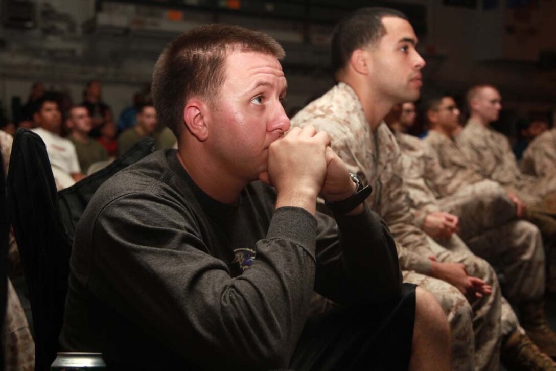 Sergeants Tim J. Kunkoski (left), motor transport non-commissioned officer-in-charge, and Yoen J. Santana, platoon sergeant, both with Transportation Support Detachment, Combat Logistics Battalion 15, 15th Marine Expeditionary Unit, watch Super Bowl XLVII during the Super Bowl party held in the hangar bay of the USS Peleliu, Feb. 4 The ship hosted a Super Bowl party for its Marines and sailors as a way to help them decompress and enjoy some of the comforts of home while being forward deployed. The 15th MEU is deployed as part of the Peleliu Amphibious Ready Group as a U.S. Central Command theater reserve force, providing support for maritime security operations and theater security cooperation efforts in the U.S. 5th Fleet area of responsibility. Kunkoski, 26, is from Baltimore, and Santana, 26, is from Brooklyn, N.Y.