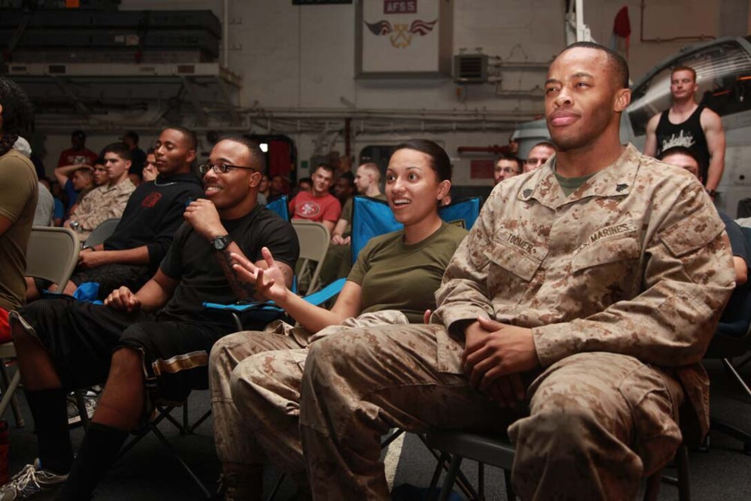 (Right to left) Sgt. Ketron L. Toomer, career planner, Cpl. Guadalupe Law, avionics technician, and Cpl. Shannon T. Burns, food service specialist, all with Marine Medium Helicopter Squadron 364 (Rein.), 15th Marine Expeditionary Unit, watch Super Bowl XLVII during the Super Bowl party held in the hangar bay of the USS Peleliu, Feb. 4. The ship hosted a Super Bowl party for its Marines and sailors as a way to help them decompress and enjoy some of the comforts of home while being forward deployed. The 15th MEU is deployed as part of the Peleliu Amphibious Ready Group as a U.S. Central Command theater reserve force, providing support for maritime security operations and theater security cooperation efforts in the U.S. 5th Fleet area of responsibility. Toomer, 24, is from Miami, Law, 23, is from Laredo, Texas, and Burns, 24, is from Detroit.