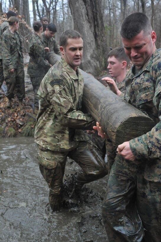 Marines work together to get a log over a water obstacle during the Montfort Point Challenge competition at the Officer Candidates School on Friday. There was no shortage of Marines slipping or sliding through water obstacles. 