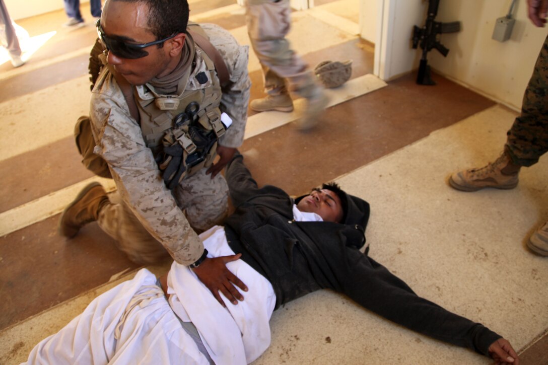 A hospital corpsman with Company F, 2nd Battalion, 4th Marine Regiment, treats a simulated civilian casualty at Range 220 Tues. 2/4 is at the conclusion of ITX and is scheduled to begin a Special Operations Training Group package.