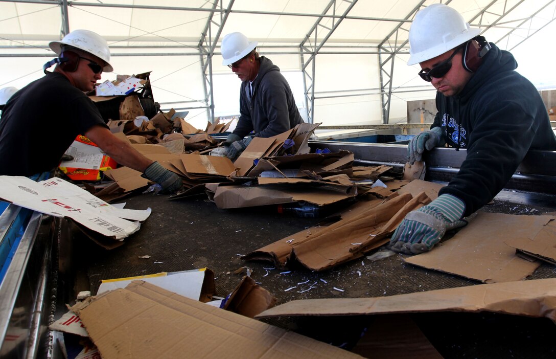Elton Munoz, left, LeRoy Edick and James Kitchak of the Qualified Recycling Program Residential Commercial Recycling Section process cardboard for baling at QRP’s commercial-industrial lot on Rifle Range Road. Each bale weighs between 1,500 and 1,700 pounds. 