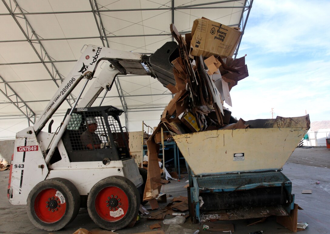 Bobcat operator Jason Smith loads cardboard into a bin for processing and baling at the Qualified Recycling Program’s commercial-industrial lot on Rifle Range Road.