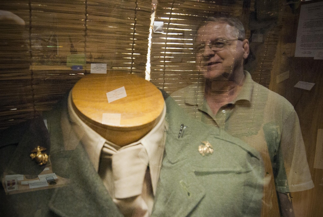 Will Price, a curator for Marine Corps League Detachment 565, reminisces about the gold Marine emblems belonging to Lt. Gen. Lewis “Chesty” Puller, kept in the detachment’s museum. The 600 square-foot museum consists of uniform and historical items. Marine Corps history is represented by an exhibit for each major conflict, containing authentic memorabilia. (U.S. Marine Corps photo by Cpl. Marcin Platek/Released)