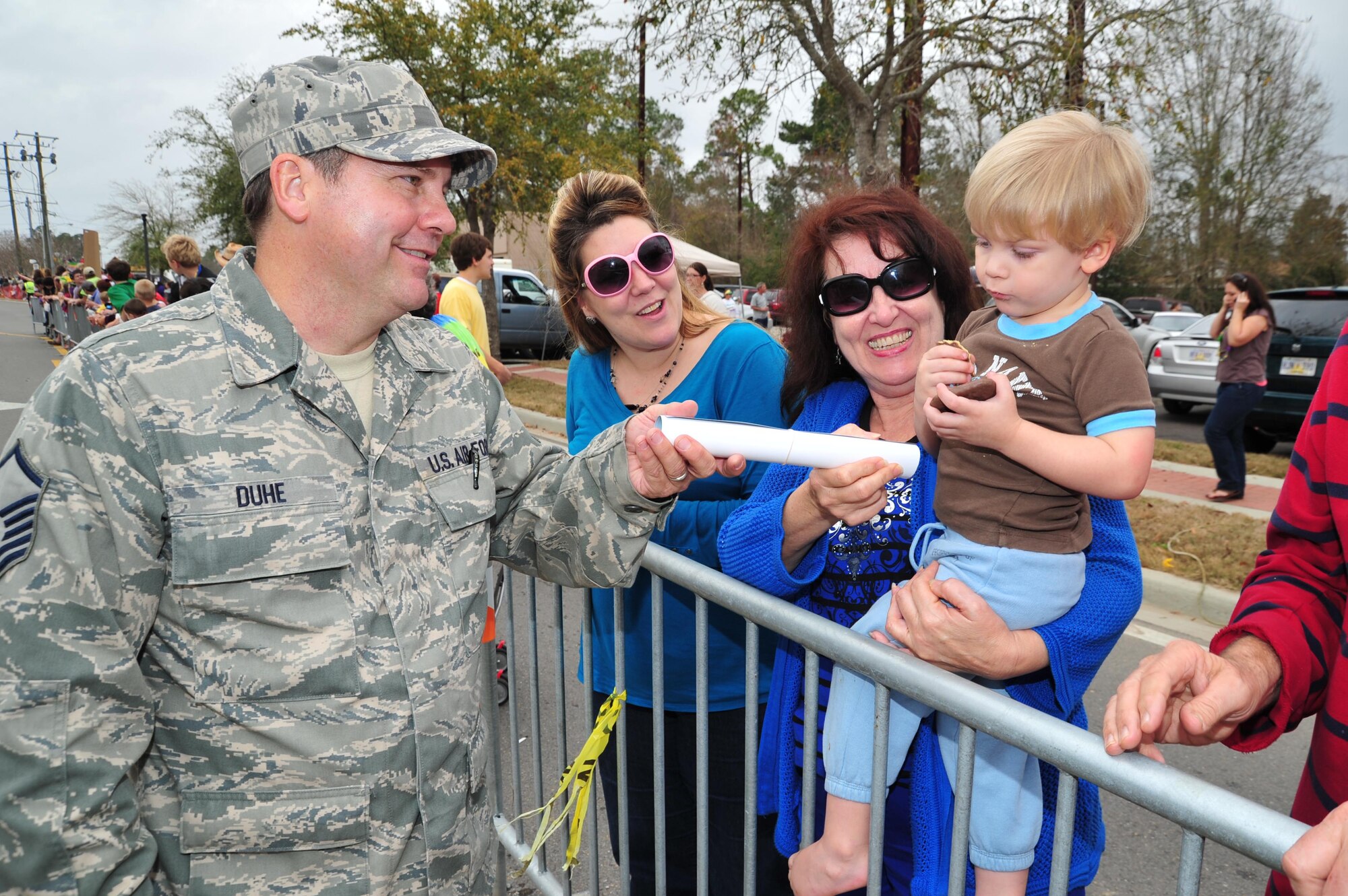Master Sgt. Michael Duhe, 403rd Wing Public Affairs photojournalist, hands an Air Force poster to a young spectator along the North Bay Mardi Gras Association parade route in D’Iberville, Miss., Feb. 10, 2013. Reservists from the 403rd Wing paraded along with members of the 81st Training Wing honor guard during the Sunday afternoon event. Both wings are stationed at Keesler Air Force Base, Miss. (U.S. Air Force photo/Tech. Sgt. Ryan Labadens)