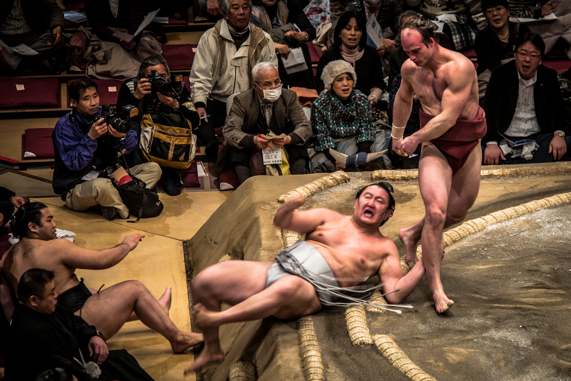 YOKOTA AIR BASE,Japan-- A Sumo wrestler throws his opponent out of the ring during the Grand Sumo Tournament at the Ryogoku Kokugikan Sumo Hall in Tokyo, Feb. 10, 2013. During a Sumo match, two wrestlers, or rikishi, attempt to force one another out of a circular ring, or dohyo. A tournament features dozens of rikishi competing in an elimination-style roster to determine the champion. (U.S. Air Force photo by Capt. Raymond Geoffroy)