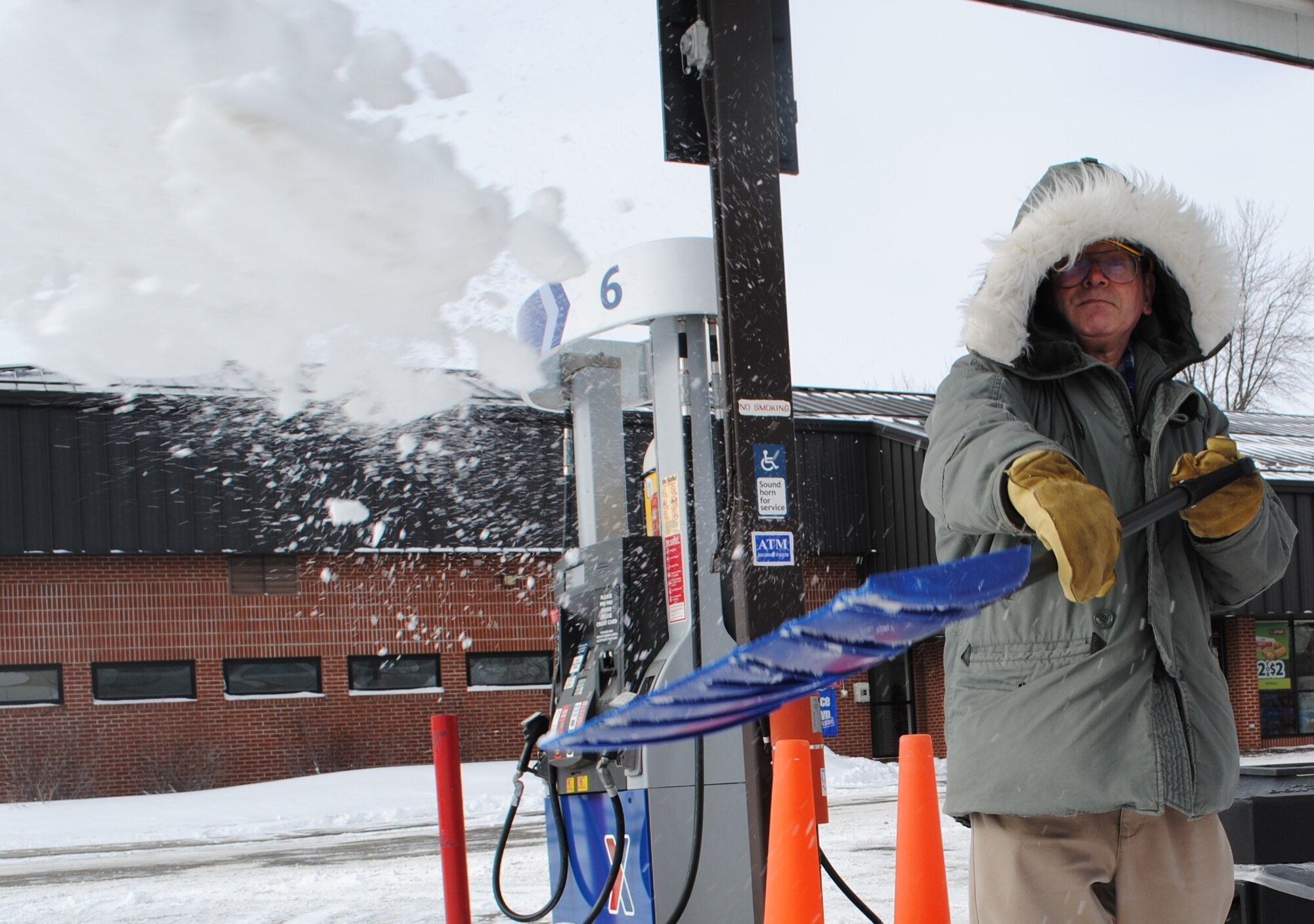 Forrest Anderson, an Army and Air Force Exchange Service custodian, shovels snow at the shoppette on Grand Forks Air Force Base, N.D., on Feb. 11, 2013. Delayed reporting to the base was implemented as a safety precaution after Winter Storm Orko brought blizzard conditions to the area on Sunday. Although the base received 2 inches of snow during the weekend, the National Weather Service received numerous reports of 12 to 18 inches of snow across northeastern South Dakota, southeastern North Dakota, and western Minnesota.  (U.S. Air Force photo/Senior Airman Luis Loza Gutierrez)
