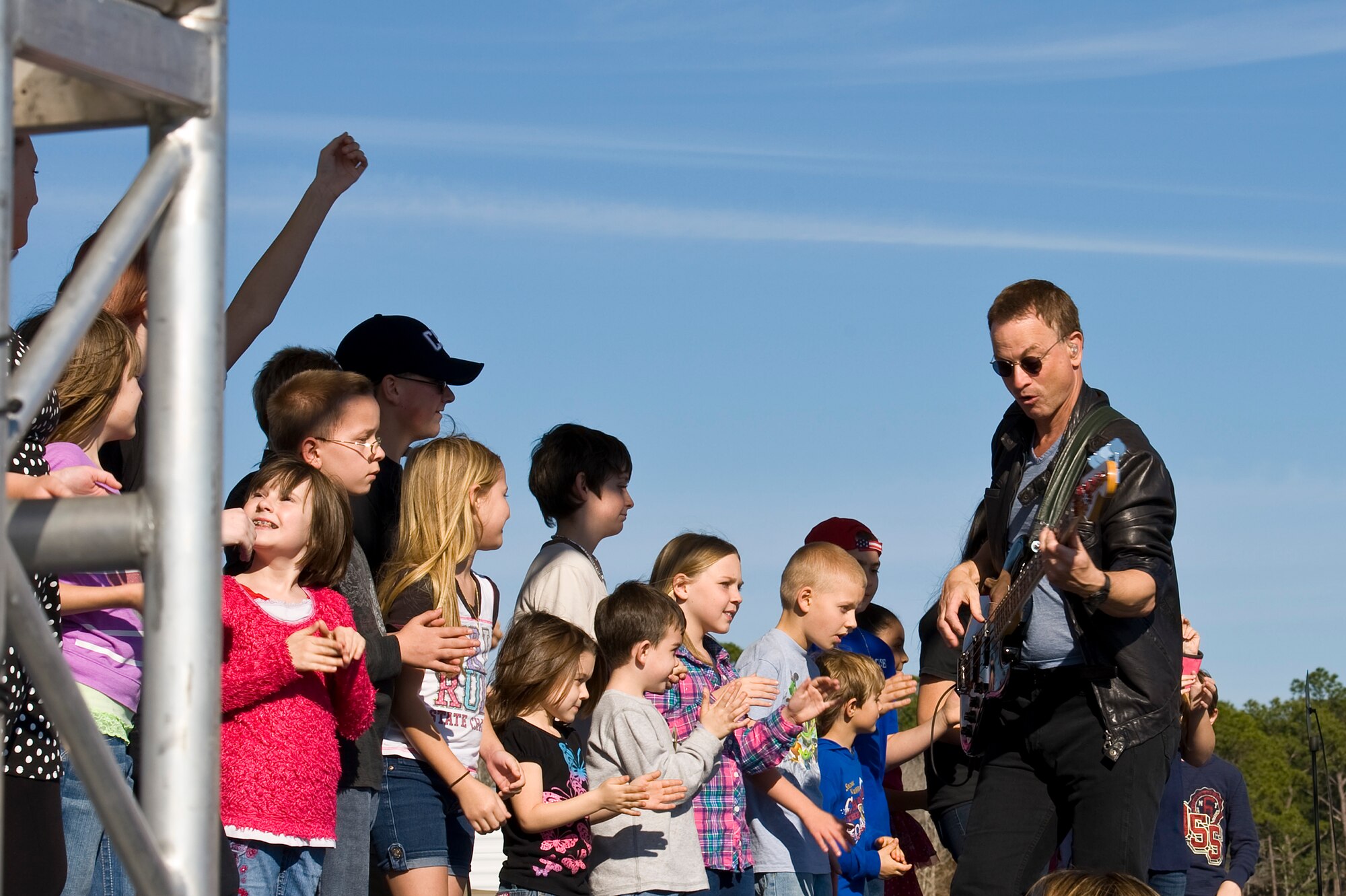 Gary Sinise and the Lt. Dan Band perform a concert for Hurlburt airmen,family and guests on the flight line on Hurlburt Field, Fla., Feb. 9, 2013.Over 3,000 people attended the free event which was sponsored by HurlburtField Force Support Squadron and the Gary Sinise Foundation.  (U.S. Air Force Photo/ Airman First Class Michelle Vickers)