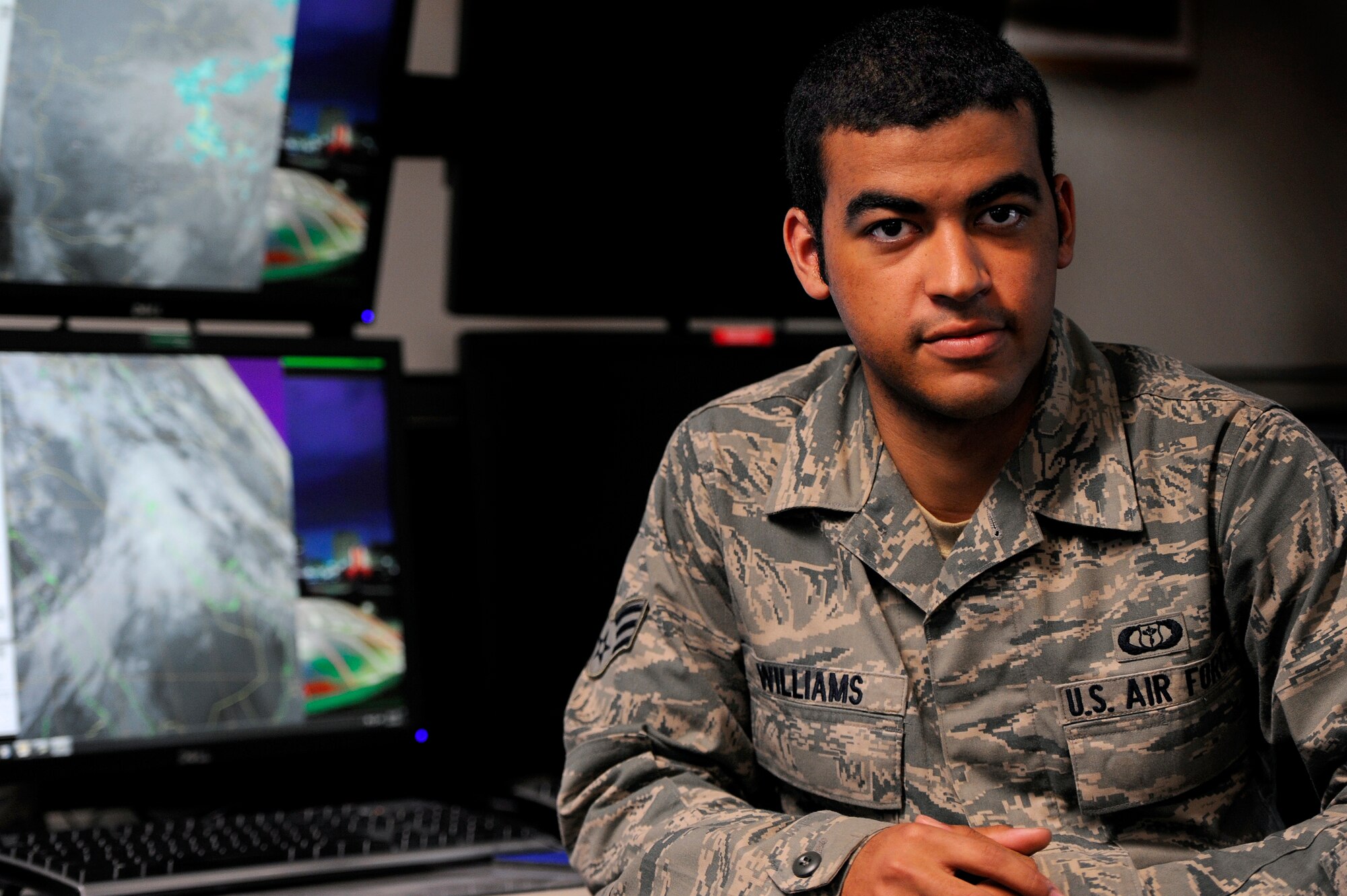 U.S. Air Force Senior Airman Patrick Williams, 28th Operational Weather Squadron weather forecaster is photographed at his desk in front of the weather monitors he uses on a daily basis to forecast the weather for pilots conducting missions in Afghanistan, Shaw Air Force Base, S.C., Feb. 11, 2013. Williams was recently the first responder on the scene of a vehicle accident where he rendered first aid to the accident victim until police officers and paramedics arrived on scene. (U.S. Air Force photo by Staff Sgt. Kenny Holston/Released) 