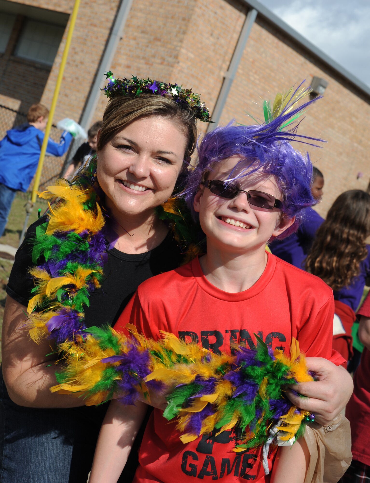 Maj. Amber Barker, 81st Medical Group, and her son, Jordan, 10, enjoy the Jeff Davis Elementary School Mardi Gras Parade in Biloxi, Miss., Feb. 8, 2013. The Keesler Honor Guard marched and Col. Mark Vivians, 81st Mission Support Group commander, and his wife, Lt. Col. Jileene Vivians, 2nd Air Force director of staff, served as grand marshals for the event.  (U.S. Air Force photo by Kemberly Groue)