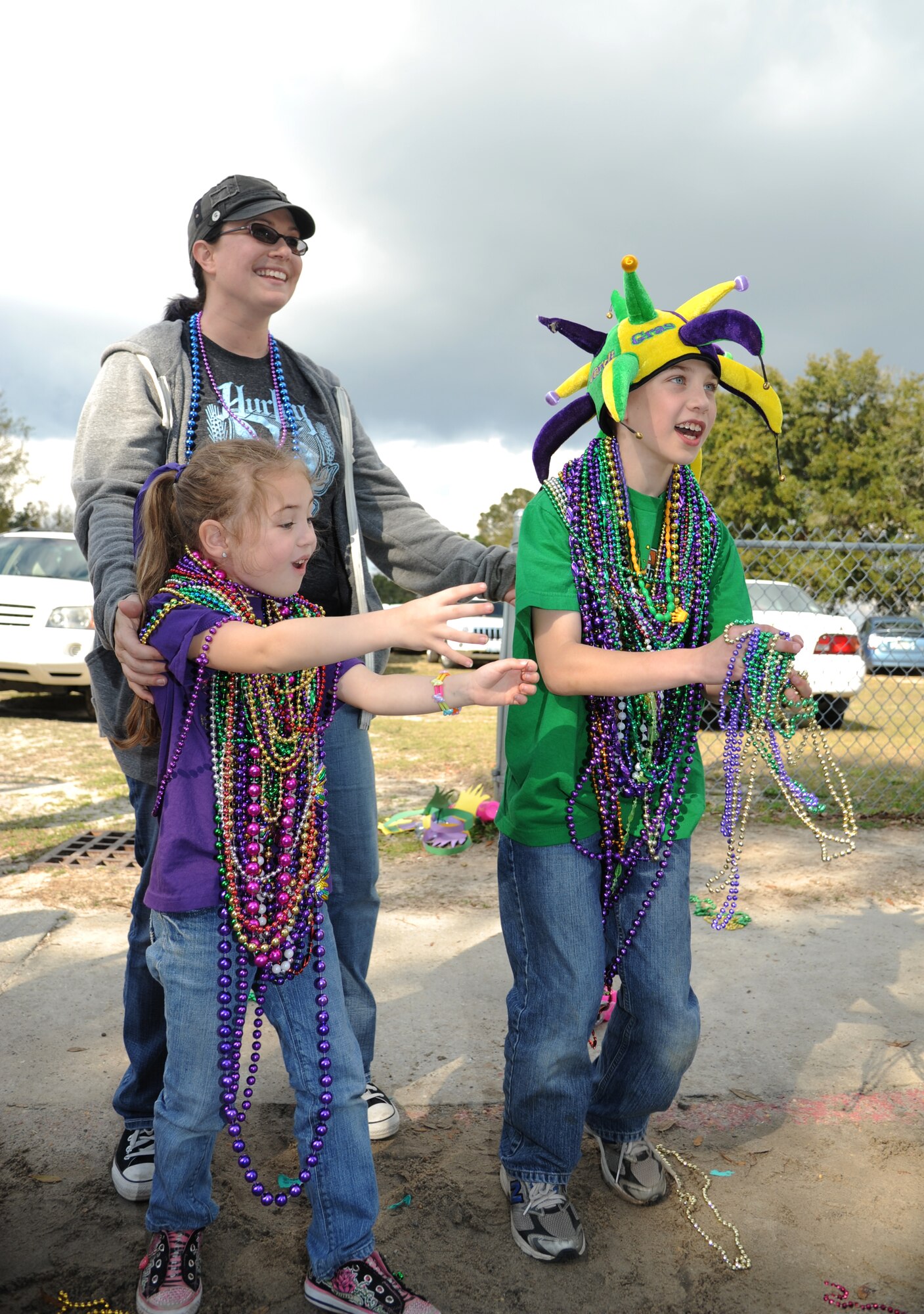 Trisha Meagher, her daughter, Felicity, 5, and son, Luke, 9, stand along the parade route to catch throws during the Jeff Davis Elementary School Mardi Gras Parade in Biloxi, Miss., Feb. 8, 2013. The Keesler Honor Guard marched and Col. Mark Vivians, 81st Mission Support Group commander, and his wife, Lt. Col. Jileene Vivians, 2nd Air Force director of staff, served as grand marshals for the event.  Meagher’s husband, Tech. Sgt. Frank Meagher, is currently deployed to Africa.  (U.S. Air Force photo by Kemberly Groue)