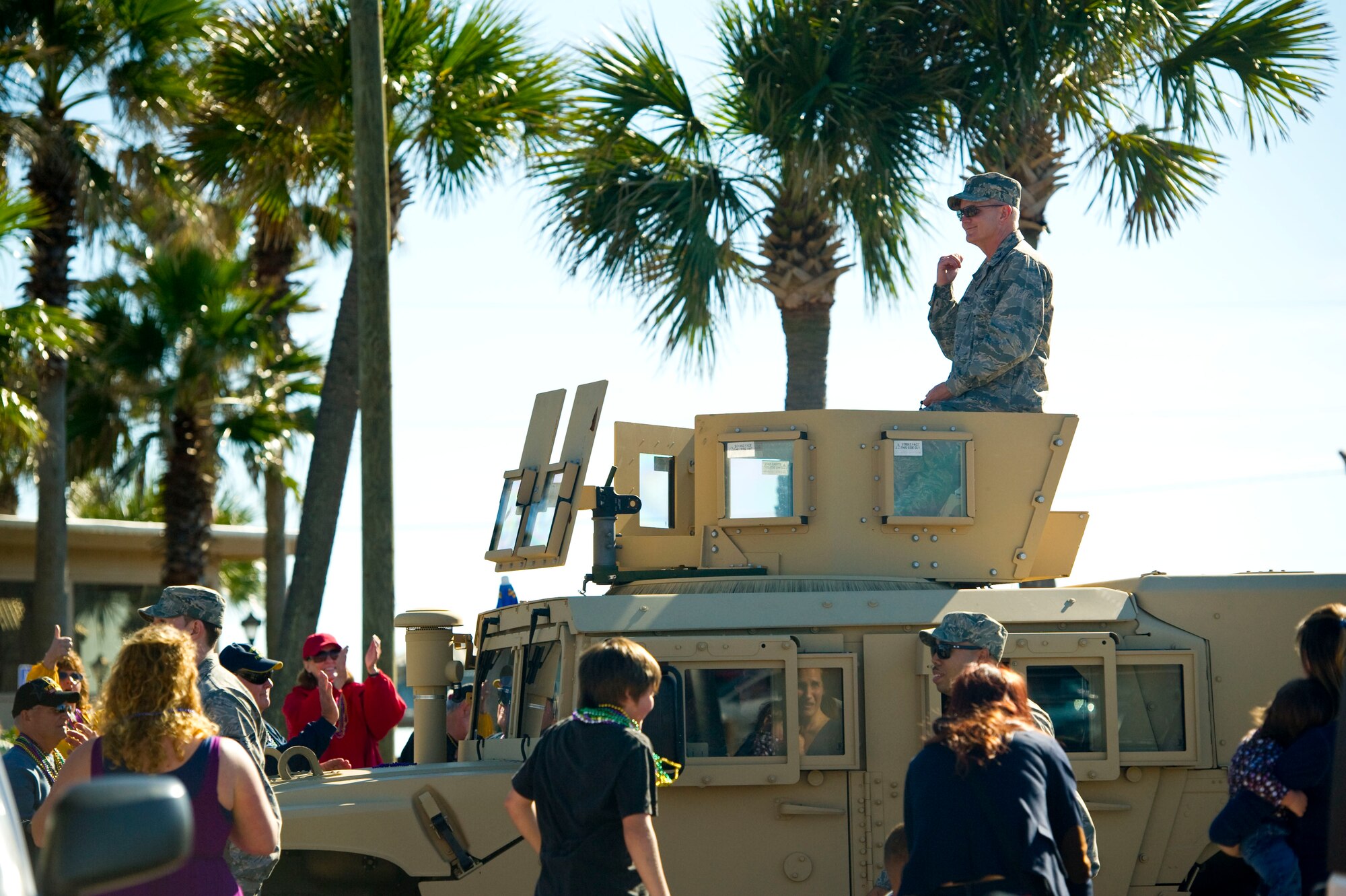 Col. Troy Molnar, commander of 1st Special Operations Medical Group, rides atop a High Mobility Multipurpose Wheeled Vehicle during a mardi gras parade at Navarre Beach, Fla., Feb. 2, 2013. Molnar was accompanied by a dozen volunteers from Hurlburt Field who walked alongside the vehicle in the parade. (U.S. Air Force photo / Tech. Sgt. Vanessa Valentine)