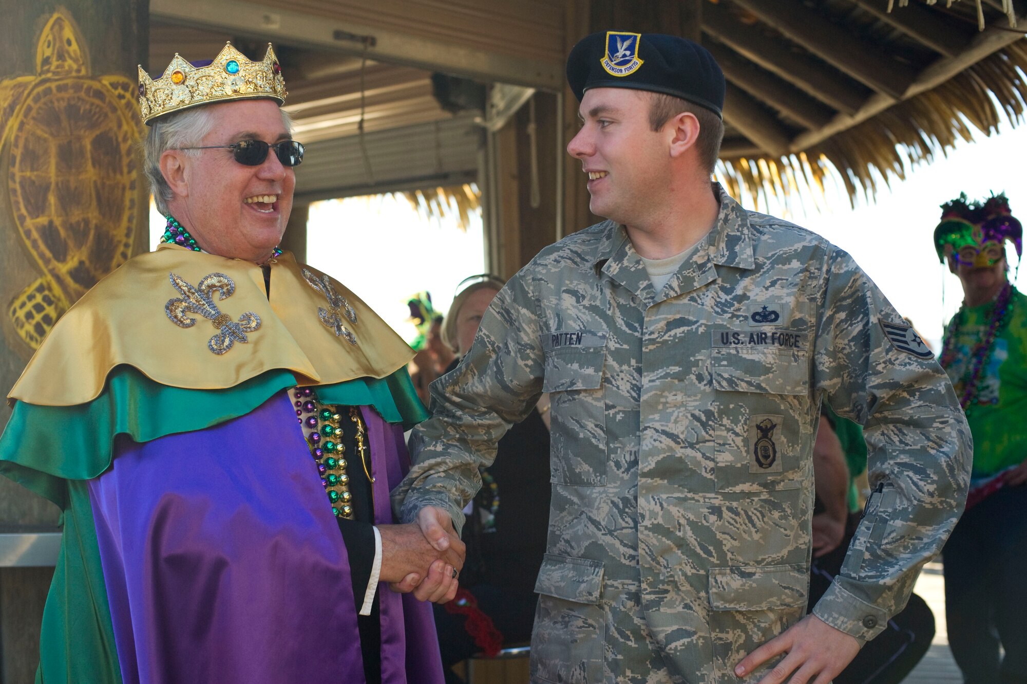 Peter Peterzen, king of the 2013 Navarre Krewe of Jesters, left, shakes hands with Staff Sgt. Alex Patten, 1st Special Operations Security Forces Squadron, right, after a mardi gras parade at Navarre Beach, Fla., Feb. 2, 2013. Patten drove a High Mobility Multipurpose Wheeled Vehicle as part of Hurlburt Field's entry in the parade. (U.S. Air Force photo / Tech. Sgt. Vanessa Valentine)