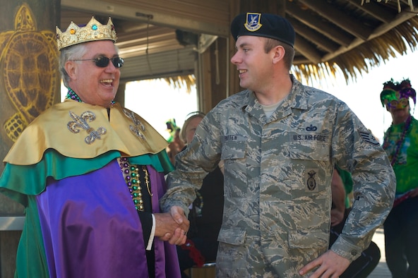 Peter Peterzen, king of the 2013 Navarre Krewe of Jesters, left, shakes hands with Staff Sgt. Alex Patten, 1st Special Operations Security Forces Squadron, right, after a mardi gras parade at Navarre Beach, Fla., Feb. 2, 2013. Patten drove a High Mobility Multipurpose Wheeled Vehicle as part of Hurlburt Field's entry in the parade. (U.S. Air Force photo / Tech. Sgt. Vanessa Valentine)