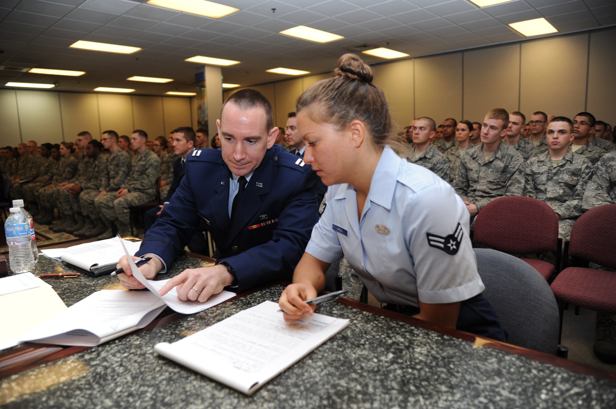 Capt. Craig Dunham, 81st Training Wing assistant staff judge advocate and trial prosecutor, and Airman 1st Class Alayna Carboni, 81st TRW paralegal, review documents during a summary court martial Feb. 8, 2013, at the Levitow Training Support Facility, Keesler Air Force Base, Miss.  Mobile summary courts martial set an example for new Airmen about consequences of their actions by quickly imposing good order and discipline.  (U.S. Air Force photo by Kemberly Groue)