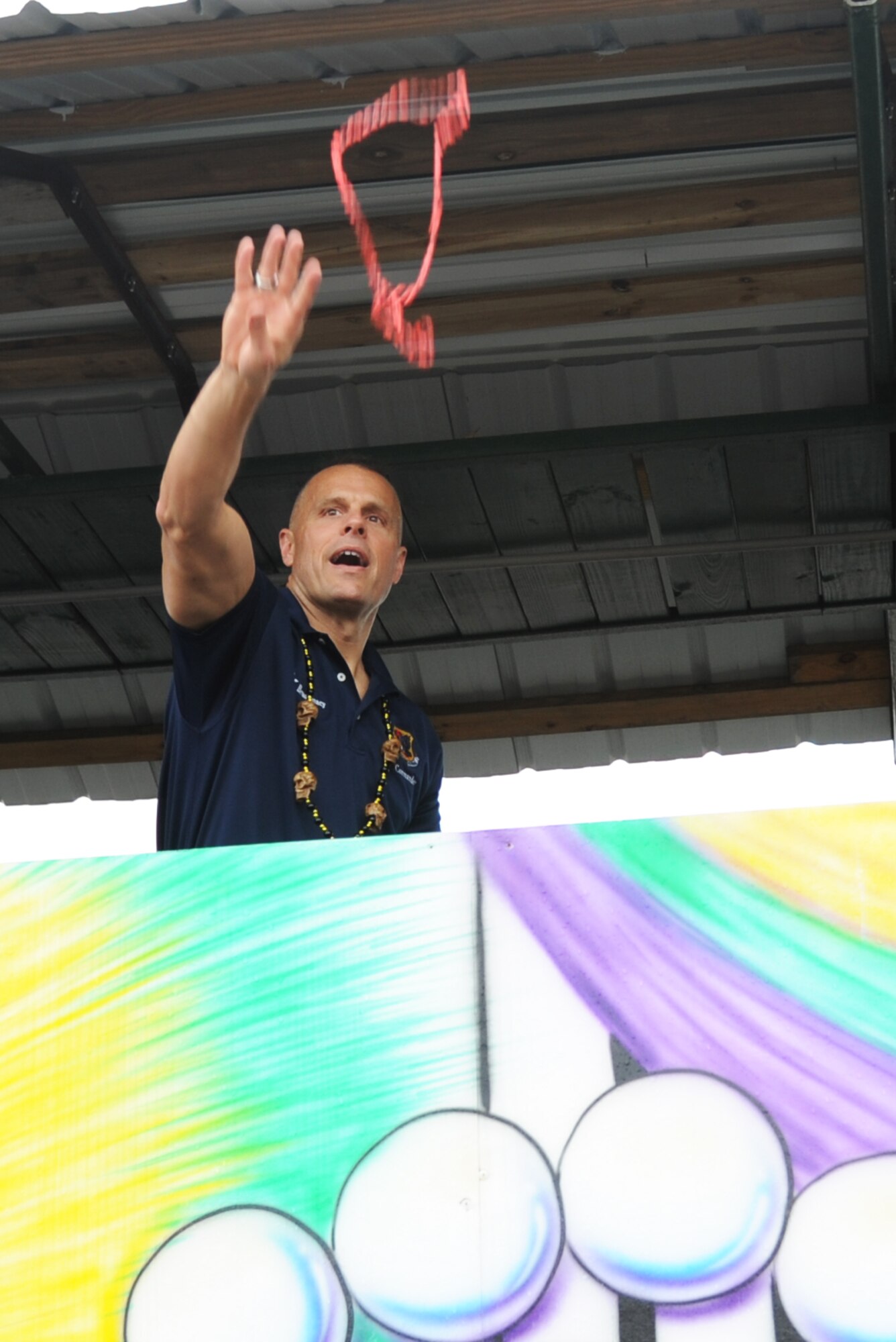 Brig. Gen. Bradley Spacy, 81st Training Wing commander, throws beads into the crowd from a float during the North Bay Area Mardi Gras Parade in D’Iberville, Miss.,  Feb. 10, 2013.  The Keesler Honor Guard and Airmen carrying the 50 state flags followed by the 81st Training Group drum and bugle corps also participated in the festivities.  (U.S. Air Force photo by Kemberly Groue)