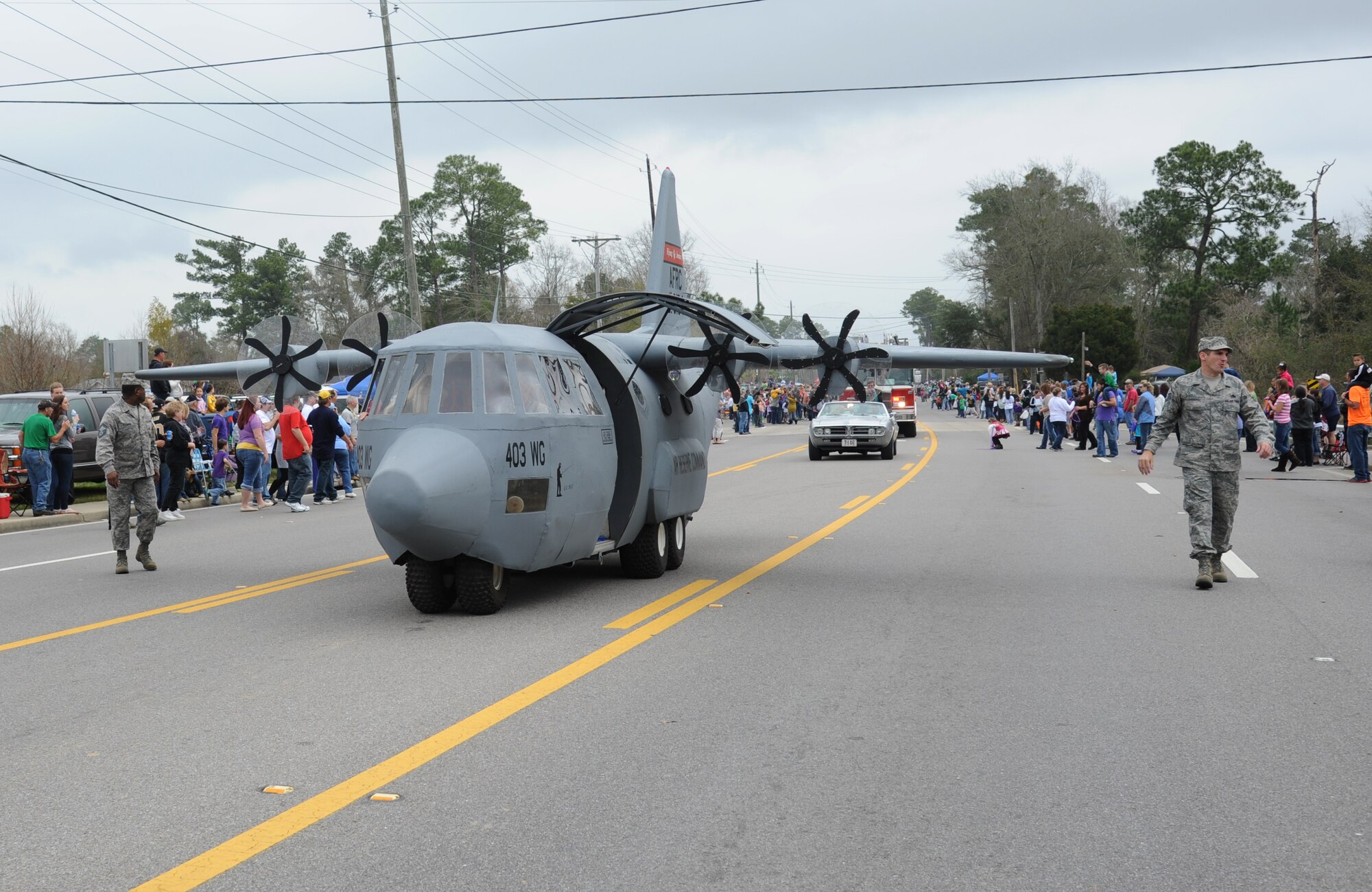 The 403rd Wing’s C-130J aircraft prototype from Keesler rolls through the crowded streets during the North Bay Area Mardi Gras Parade in D’Iberville, Miss., Feb. 10, 2013.  Leadership from the 81st Training Wing, the Keesler Honor Guard, Airmen carrying the 50 state flags and the 81st Training Group drum and bugle corps also participated in the festivities.  (U.S. Air Force photo by Kemberly Groue)