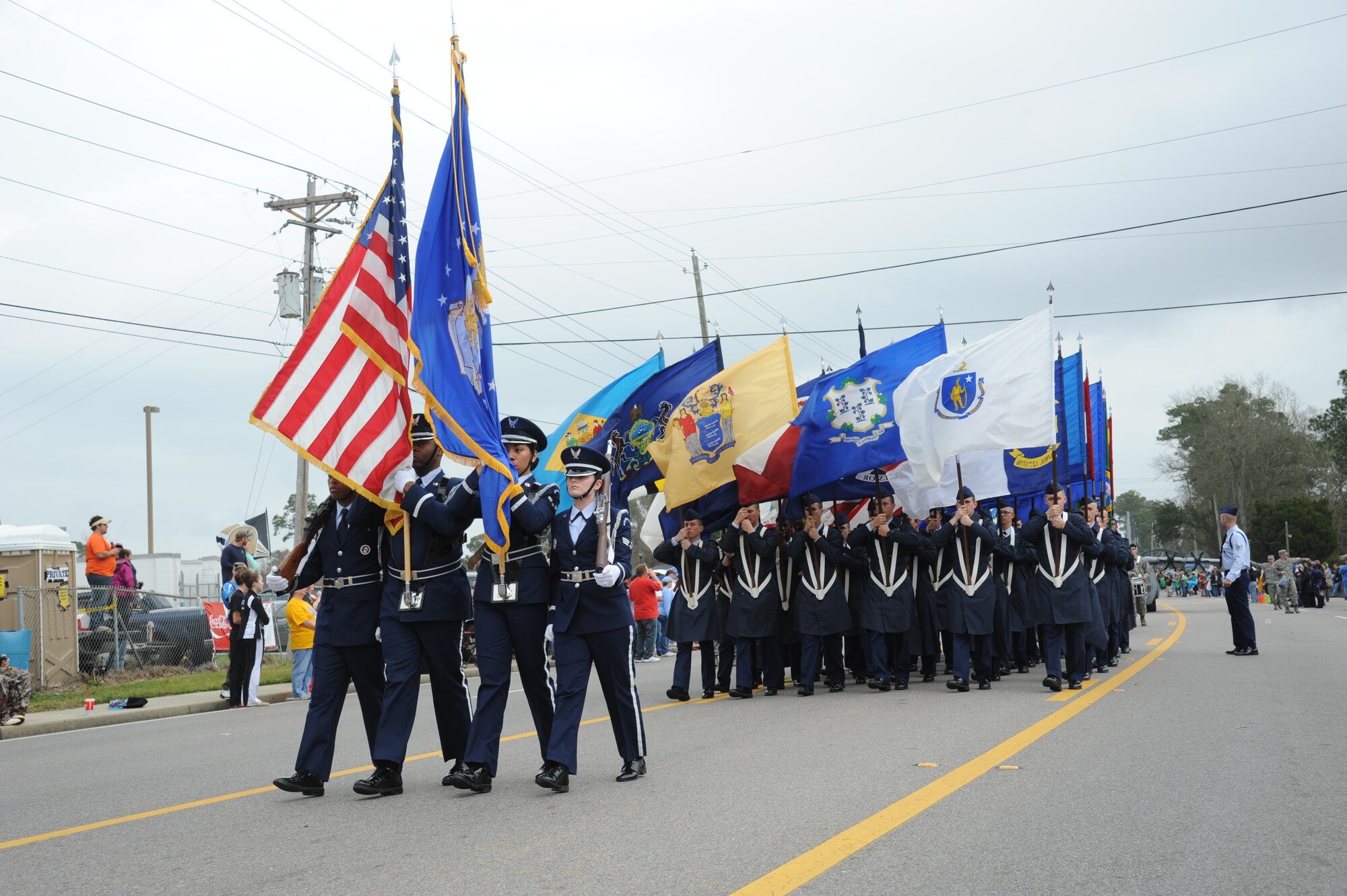 The Keesler Honor Guard and Airmen carrying the 50 state flags lead the North Bay Area Mardi Gras Parade in D’Iberville, Miss., Feb. 10, 2013.  Leadership from the 81st Training Wing and the 81st Training Group drum and bugle corps also participated in the festivities.  (U.S. Air Force photo by Kemberly Groue)
