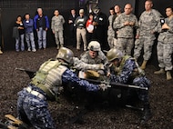 Military personnel, part of the Defense Medical Readiness Training Institute, deploy a stretcher to simulate a real-time medical evacuation at Joint Base San Antonio-Camp Bullis Feb. 8. Texas state legislators took part in an immersion tour that included mount towns, simulated medical evacuations and live fire demonstrations at Camp Bullis. (U.S. Air Force photo by Benjamin Faske) (released)