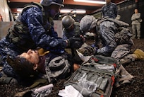 Military personnel, part of the Defense Medical Readiness Training Institute, conduct a simulated medical evacuation at Joint Base San Antonio-Camp Bullis Feb. 8. Texas state legislators took part in an immersion tour that included mount towns, simulated medical evacuations and live fire demonstrations at Camp Bullis. (U.S. Air Force photo by Benjamin Faske) (released)