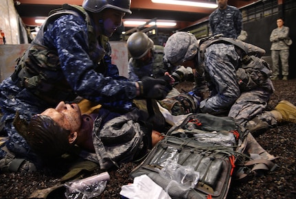 Military personnel, part of the Defense Medical Readiness Training Institute, conduct a simulated medical evacuation at Joint Base San Antonio-Camp Bullis Feb. 8. Texas state legislators took part in an immersion tour that included mount towns, simulated medical evacuations and live fire demonstrations at Camp Bullis. (U.S. Air Force photo by Benjamin Faske) (released)