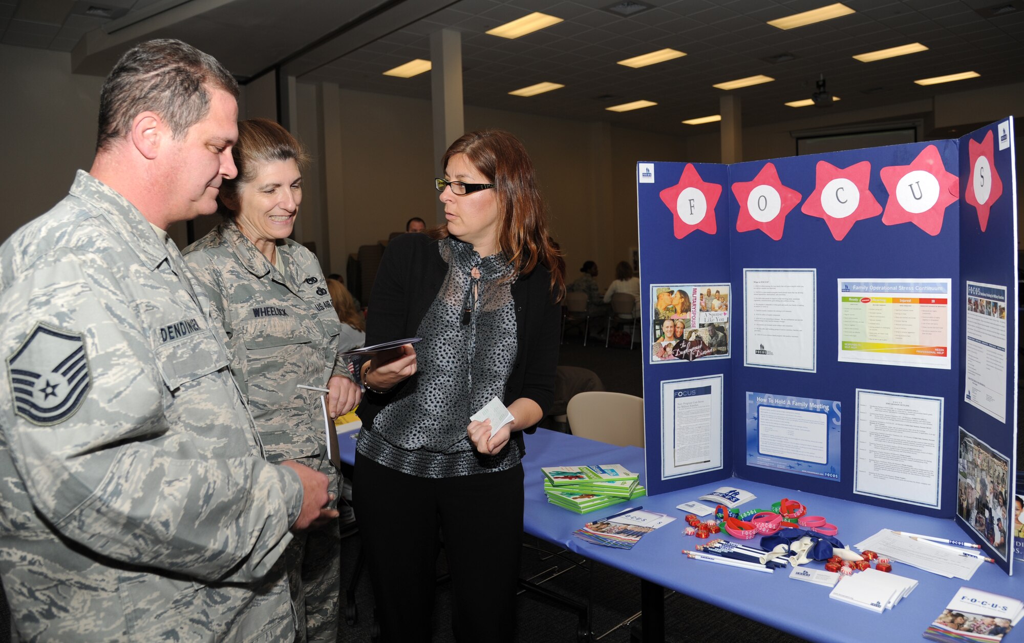 Master Sgts. John Dendinger and Kathy Wheelock, 403rd Maintenance Squadron, listen to Kim Perez, 81st Force Support Squadron and Families OverComing Under Stress Keesler site director, on the FOCUS program, a military family resiliency training program, during the military preparedness exposition Feb. 7, 2013, at the Roberts Consolidated Aircraft Maintenance Facility.  Various agencies set up information displays and booths to assist those who have recently returned from a deployment or will soon be deploying.  (U.S. Air Force photo by Kemberly Groue)