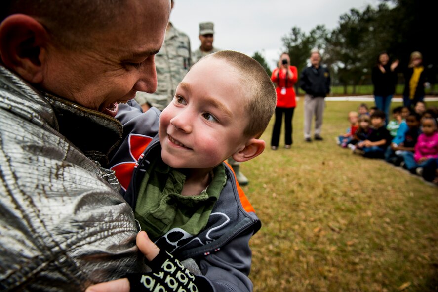 U.S. Air Force Tech. Sgt. Eric Kunzman, former 23d Civil Engineer Squadron firefighter, hugs his son, Christian, after reuniting with him Feb. 8, 2013, at Sallas Mahone Elementary School, Valdosta, Ga. Kunzman returned home after serving a year-long tour to Osan Air Base, Korea and surprised his son in what was thought to be a normal fire-safety demonstration at the school. (U.S. Air Force photo by Staff Sgt. Jamal D. Sutter/Released) 