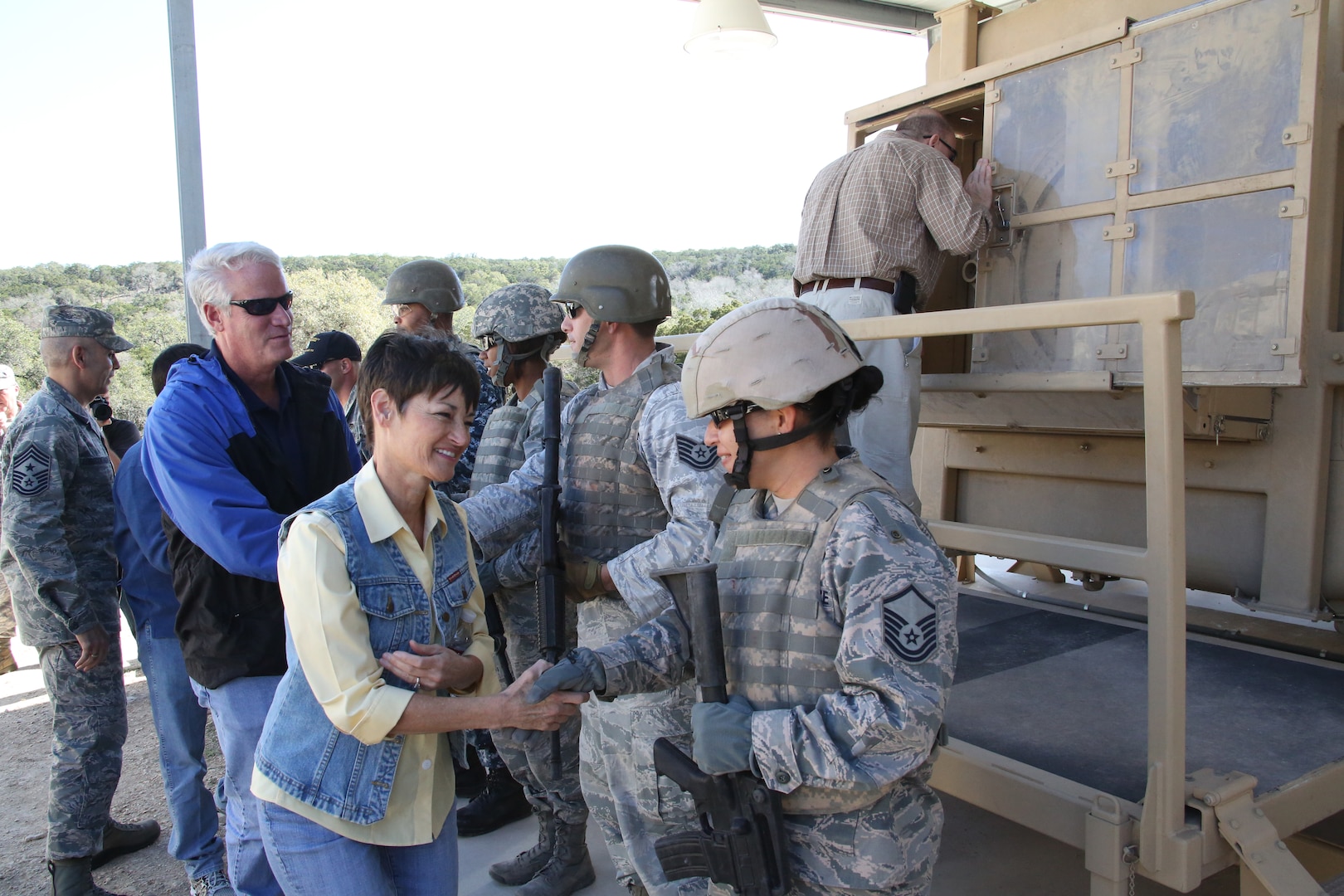 Texas Sen.  Donna Campbell shakes hand with Air Force Master Sgt. Pearl Alvarezswartz, while in back, Texas Rep. Lyle Larson, shakes hands with Air Force Tech Sgt. Jeremy Oulette after the HMMWV Egress Assistance Trainer exhibition.  Texas Legislative Day was hosted by the 502nd Air Base Wing and held at Joint Base San Antonio-Camp Bullis Feb. 8.   (U.S. Air Force photo by Joel Martinez)