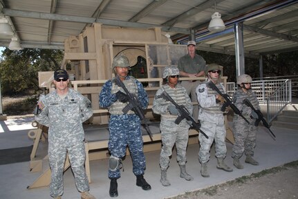 Providing demonstrations and explanations for the HMMWV Egress Assistance Trainer during the Texas Legislative Tour at Joint Base San Antonio-Camp Bullis are, front row from left:  Army Staff Sgt. Royce Mainville, Navy Hospital Corpsman Robert Jones, Air Force Staff Sgt. Deloran Lomax, Air Force Technical Sgt. Jeremy Oulette and Master Sgt. Pearl Alvarezswartz.  Standing behind is Ron Lane, operations and training area coordinator for Army Support Activity.  Texas Legislative Day was hosted by the 502nd Air Base Wing and held at Joint Base San Antonio-Camp Bullis Feb. 8.   (U.S. Air Force photo by Joel Martinez)