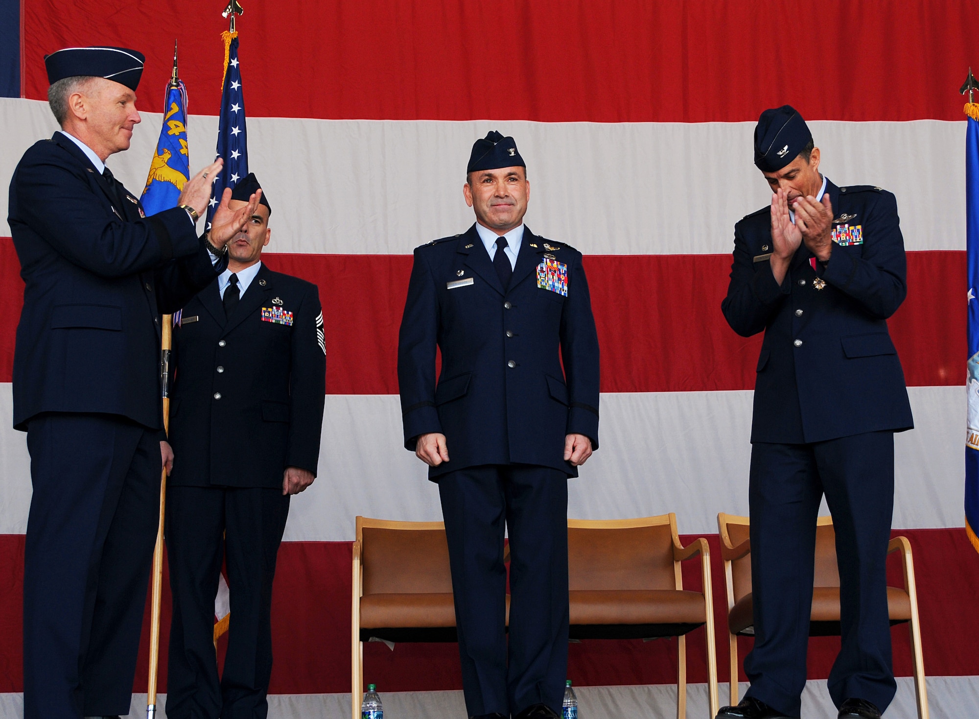 Maj. Gen. William B. Binger and Col. Jose R. Monteagudo congratulate newly assigned 944th Fighter Wing Commander Col. Kurt J. Gallegos with applause after a change-of-command ceremony at Luke Air Force Base here, Feb. 10.   (U.S. Air Force Photo by Tech. Sgt. Louis Vega) 