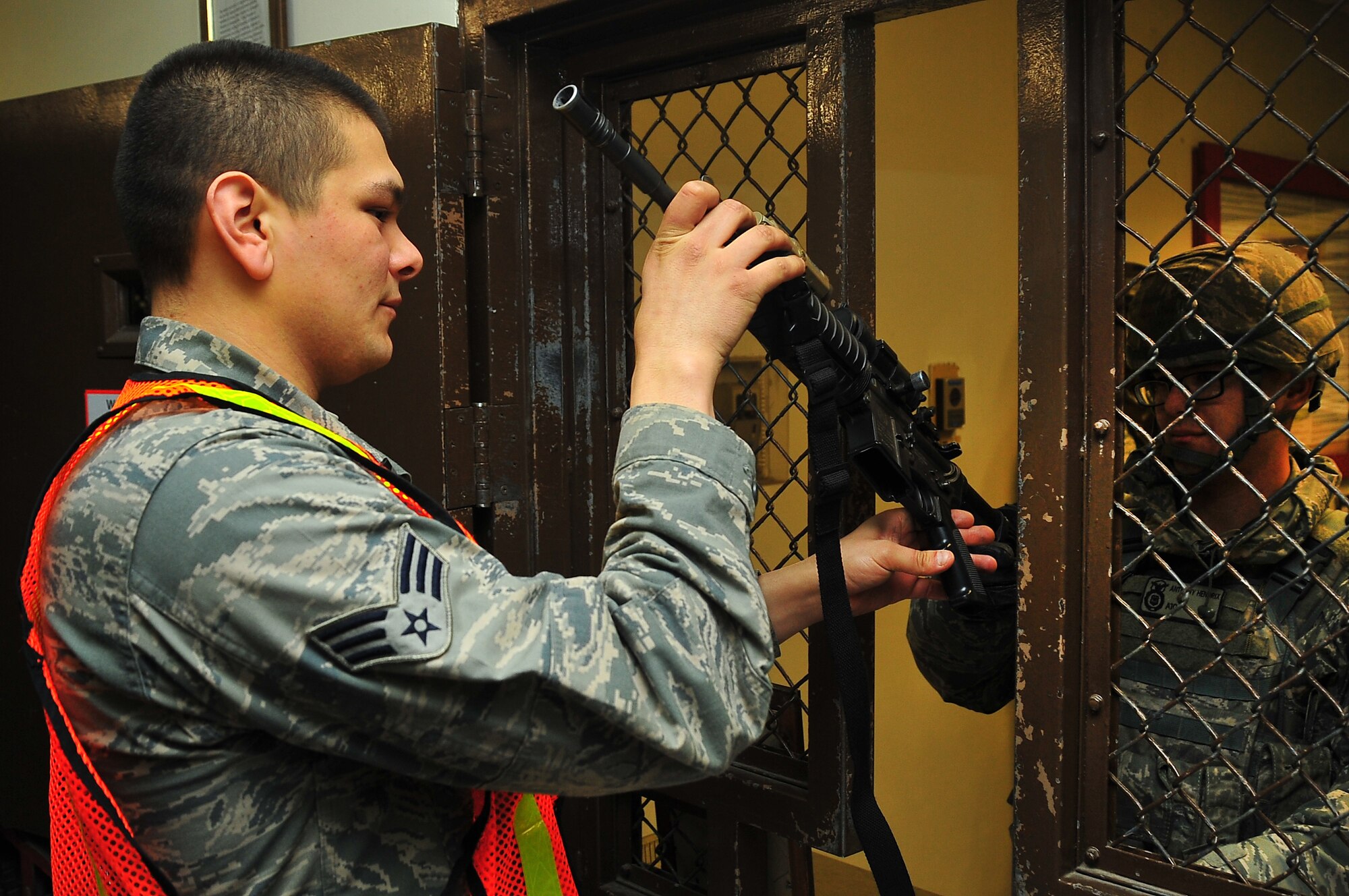 Senior Airman Pefiler, 51st Security Forces Armourer, arms up Airman 1st Class Anthony Hendrix, 51st Security Forces member in building 1425 at Osan Air Base, Republic of Korea, Feb. 11, 2013.  Security Forces members ready themselves for exercise Beverly Bulldog 13-02, Airmen highlight their ability to position, employ, and sustain forces and showcase operational readiness.  (U.S. Air Force photo/Staff Sgt. Emerson Nuñez)
