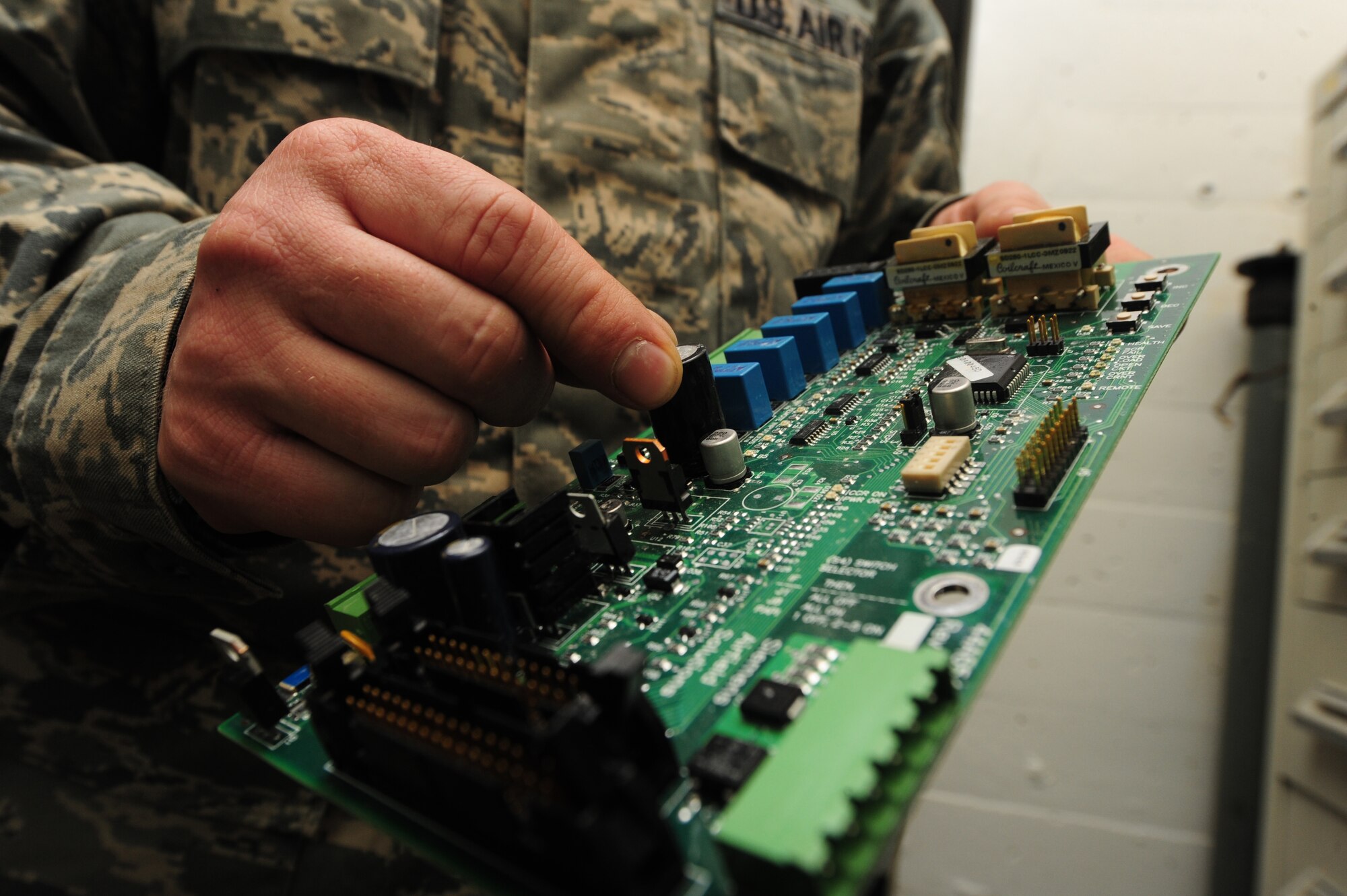 WHITEMAN AIR FORCE BASE, Mo. -- Staff Sgt. Clint Smith, 509th Civil Engineer Squadron electrical systems craftsman, checks to see if a circuit board is in operable condition, Jan. 29. Visually inspecting circuit boards for defects and damage is part of the routine maintenance electricians perform on electrical systems every day. (U.S. Air Force photo/Staff Sgt. Nick Wilson) (Released)