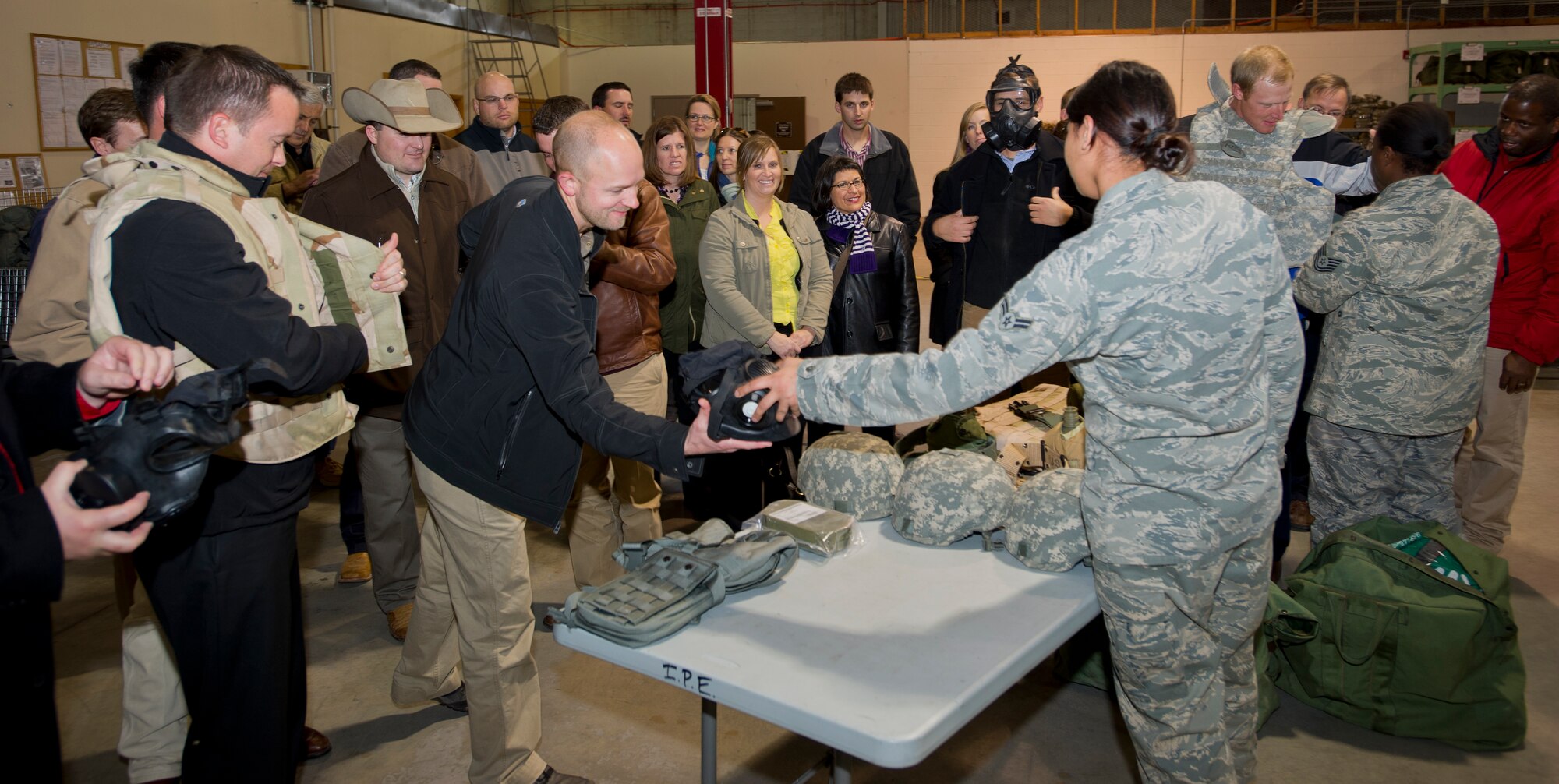 Members of the Kansas Agriculture and Rural Leadership program try on protective equipment used by Airmen during a tour Feb. 2, 2013, McConnell Air Force Base, Kan. More than 30 KARL members experienced how McConnell provides support to the warfighter with an orientation flight and tour of the base. (U.S. Air Force photo/Senior Airman Armando A. Schwier-Morales)