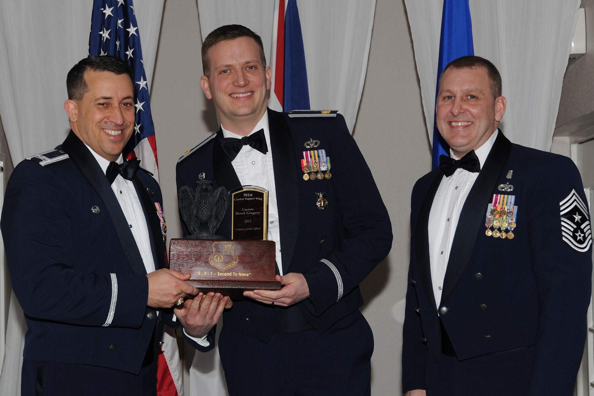 RAF CROUGHTON, United Kingdom –Maj. Richard Martin, 423rd Civil Engineer Squadron commander, accepts the 501st Combat Support Wing’s Company Grade Officer of the Year award on behalf of Capt. Derek Gregory, 423rd CES, during the 501st CSW Annual Awards at RAF Croughton Feb. 8. Gregory led a 92-member workforce in the execution of 14,000 work orders, 65,000 man-hours and $4.8 million worth of MoD labor resulting in real property valued at $1.2 billion being mission ready. He also deployed as a joint engineer project manager where he validated, reviewed and solicited approval for projects valued at $6 million spanning six regional commands and 330 bases. (U.S. Air Force photo by Tech. Sgt. Chrissy Best)