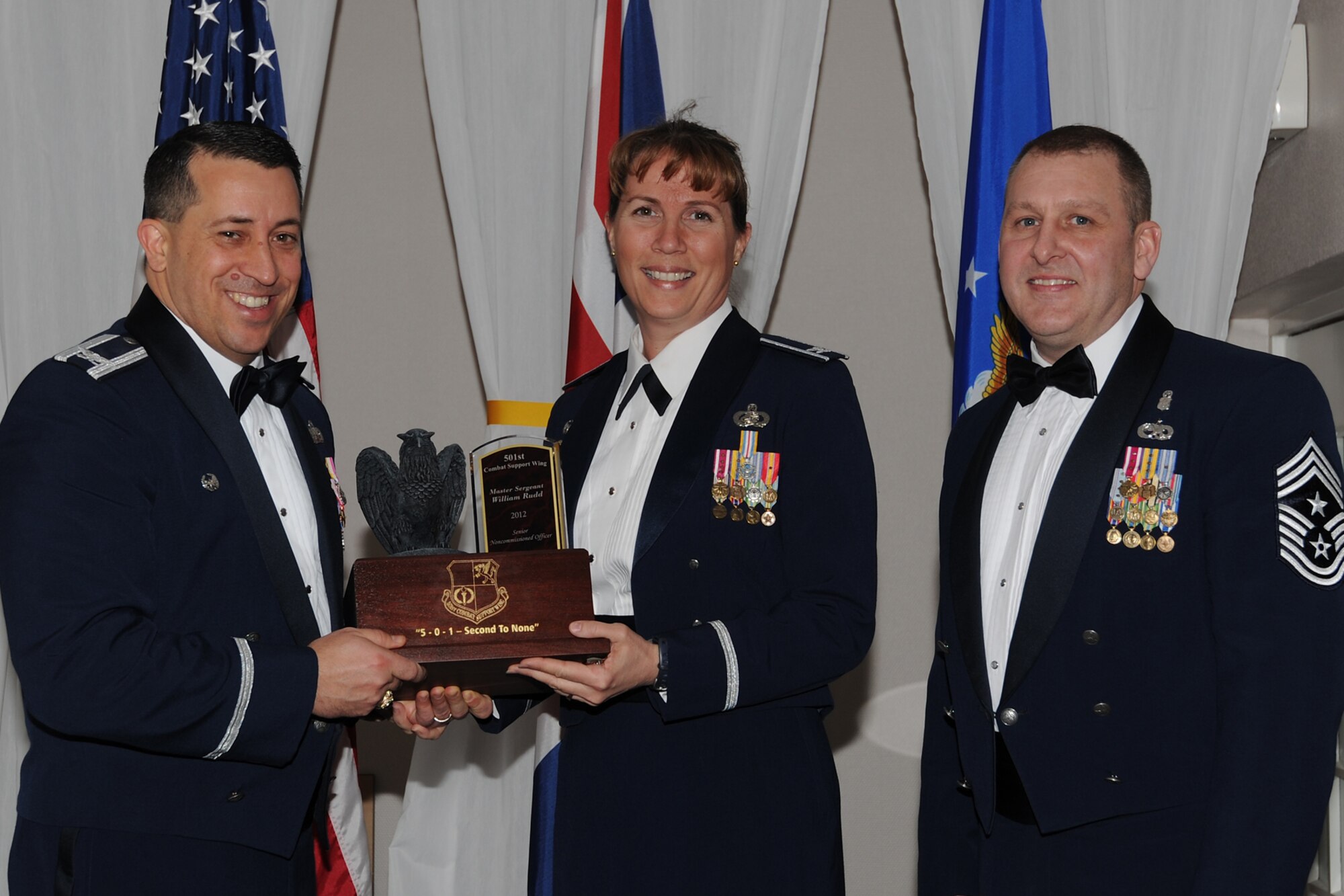 RAF CROUGHTON, United Kingdom –Col. Mary Boucher, 421st Air Base Group commander, accepts the 501st Combat Support Wing’s Senior NCO of the Year award on behalf of Master Sgt. William Rudd, 421st Air Base Group legal office, during the 501st CSW Annual Awards at RAF Croughton Feb. 8. Rudd led the legal office through the Consolidated Unit Inspection and was rated the best office in USAFE and the second of 21 offices inspected Air Force-wide. Rudd was also selected for the Coast Guard Chief Petty Officer School. (U.S. Air Force photo by Tech. Sgt. Chrissy Best)