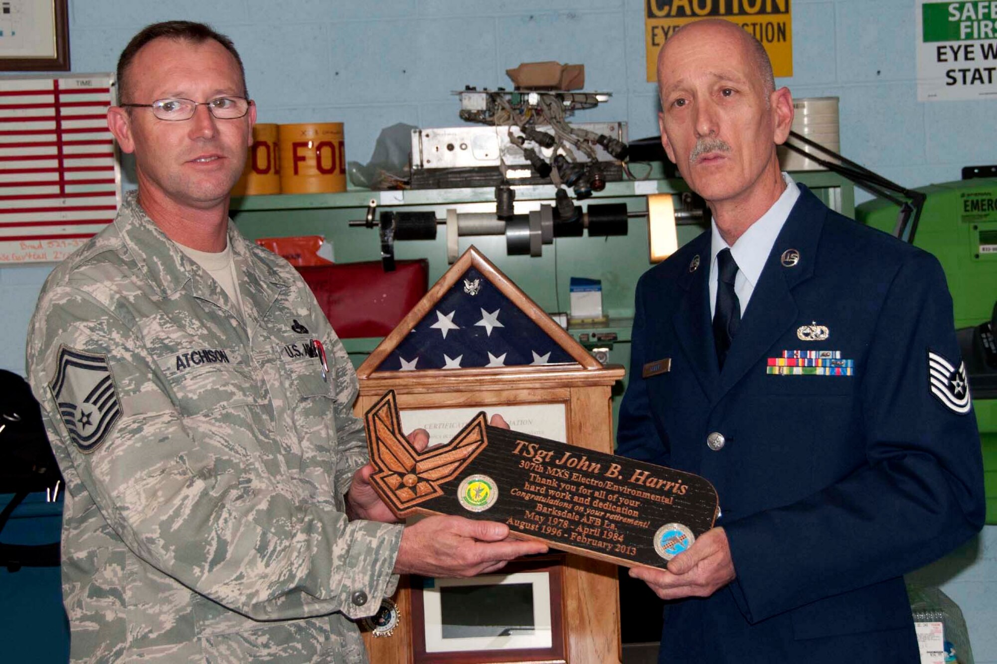 Senior Master Sgt. Kenneth Atchinson, who is the 307th Maintenance Squadron accessory flight chief, presents a plaque of appreciation to Tech. Sgt. John Harris, electrical and environmental systems mechanic, 307 MXS, at Barksdale Air Force Base, La., Feb. 9, 2013.  Harris accepted the gift during his retirement ceremony where he thanked members of the 307 MXS for the opportunity to serve with them.  He encouraged them to continue to display the professionalism they showed during his time in the unit. (U.S. Air Force by Tech. Sgt. Ted Daigle)