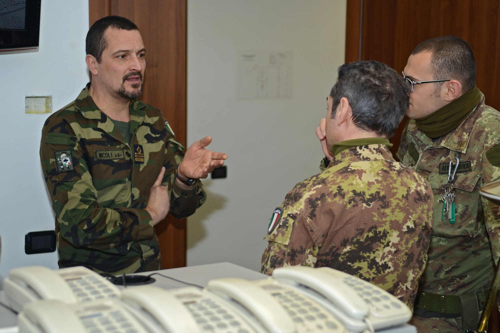 Lt. Col. Piero Micoli, Italian air force security forces commander at Aviano, talks with members of the ITAF SF in the Consolidated Operations Desk Jan. 29, 2013, on Aviano Air Base, Italy. The COD helps the 31st Security Forces Squadron and ITAF effectively communicate critical information on base.  (U.S. Air Force photo / Senior Airman Jessica Hines)